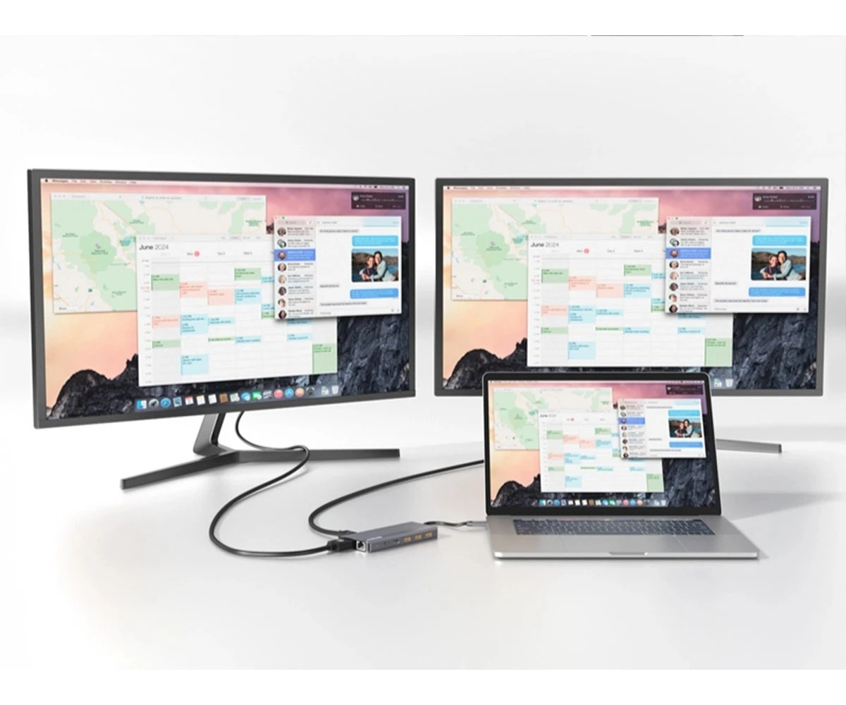 Laptop jest połączony z dwoma dużymi monitorami za pomocą huba USB-C, wyświetlając kalendarze i aplikacje.