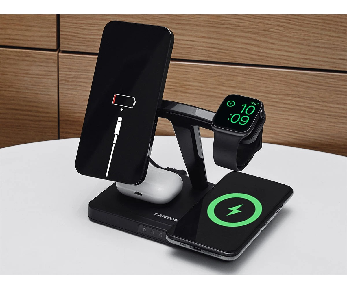 Czarna stacja ładująca Canyon na stole ładuje smartfon, smartwatch i bezprzewodowe słuchawki.