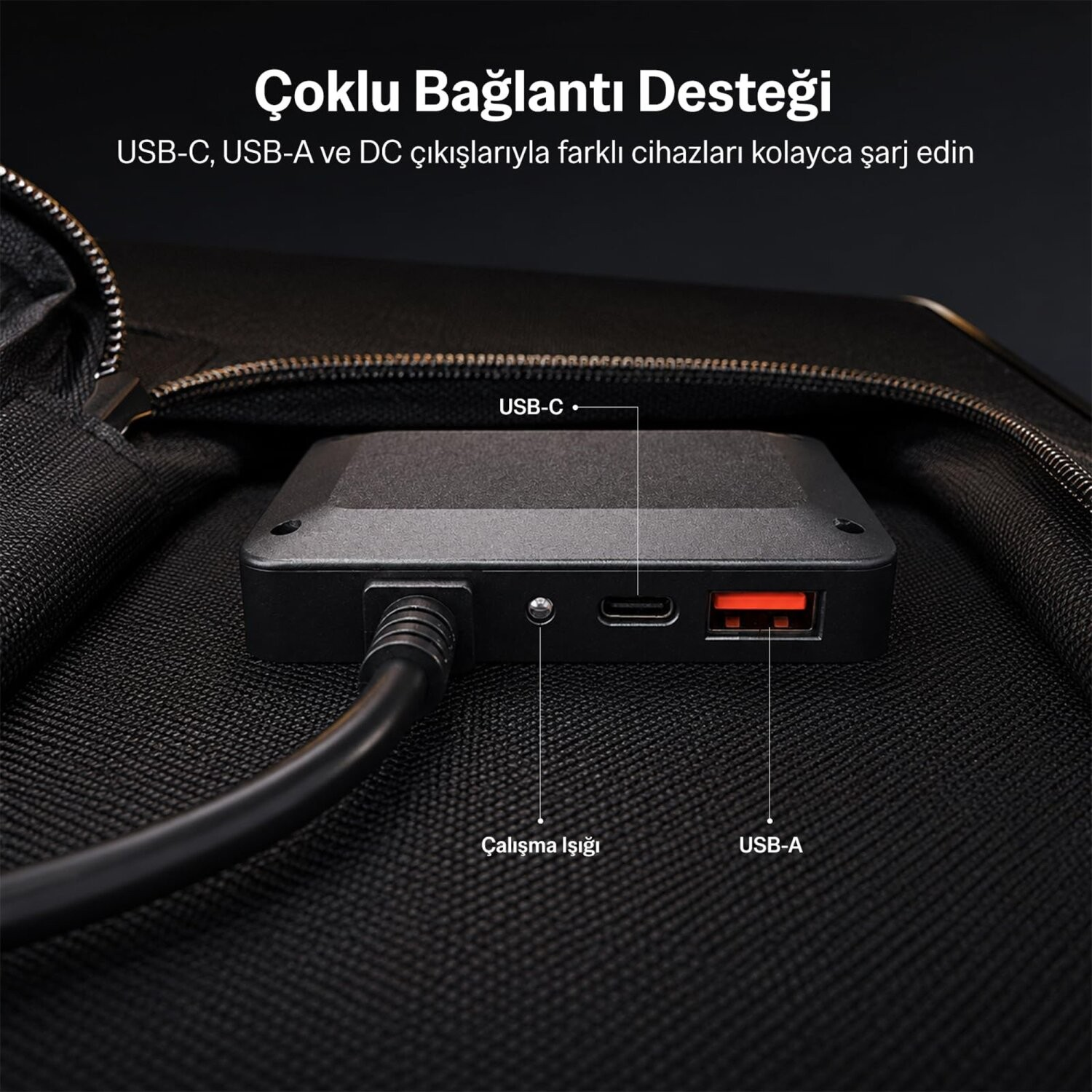 Dokulu yüzeyde USB-C, USB-A portları ve güç kablosu olan siyah güç merkezi.