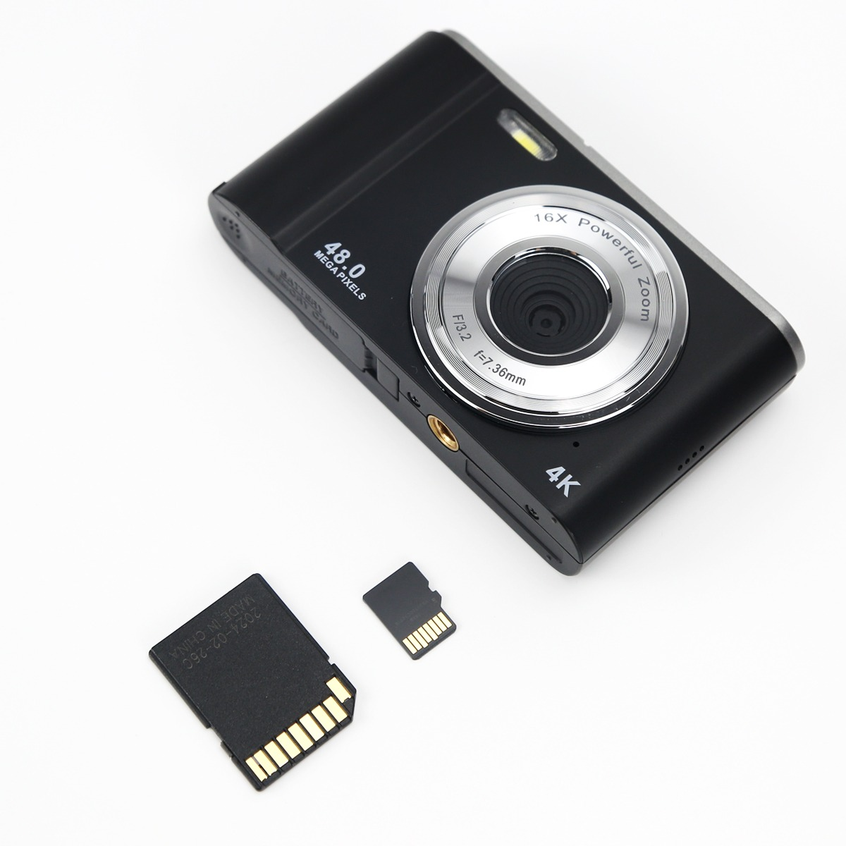A black 4K digital camera with 48 megapixels and two memory cards on a white background.