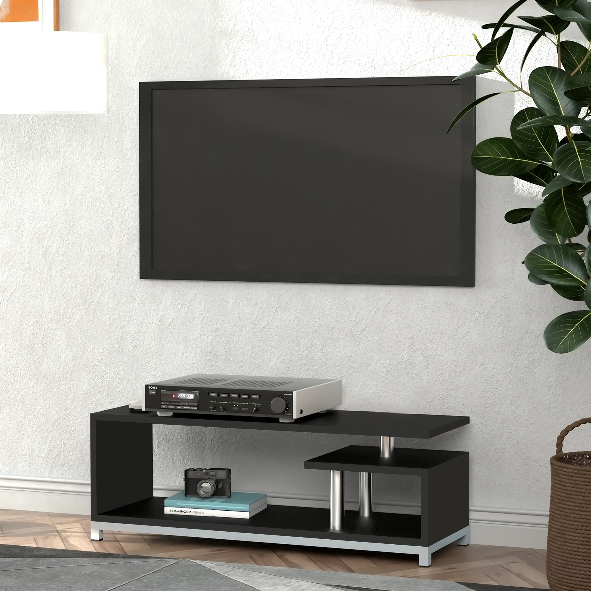Una TV nera a parete sopra un moderno mobile TV nero con un ricevitore e una fotocamera.