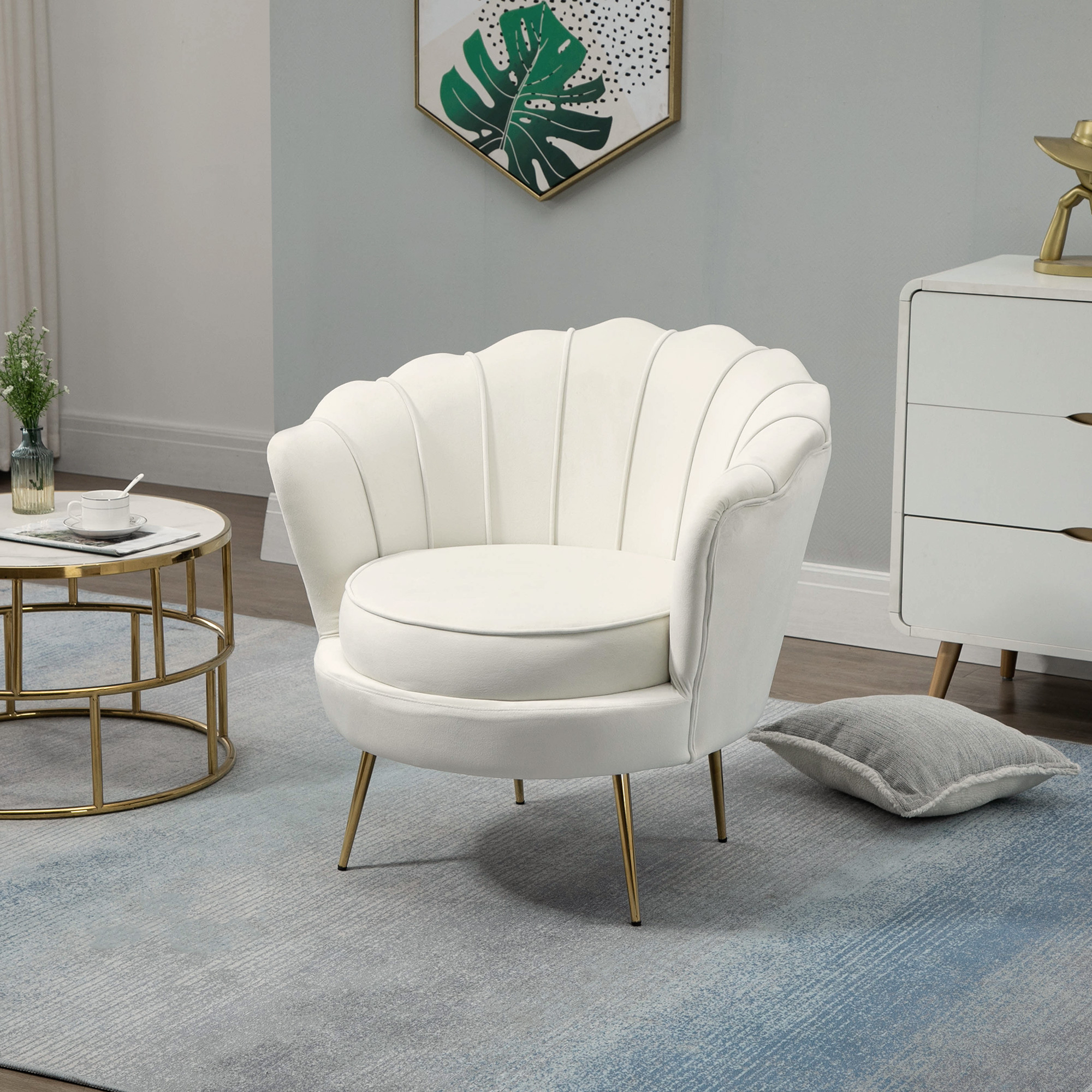 Una poltrona in velluto bianco a forma di conchiglia con gambe dorate su un tappeto blu.