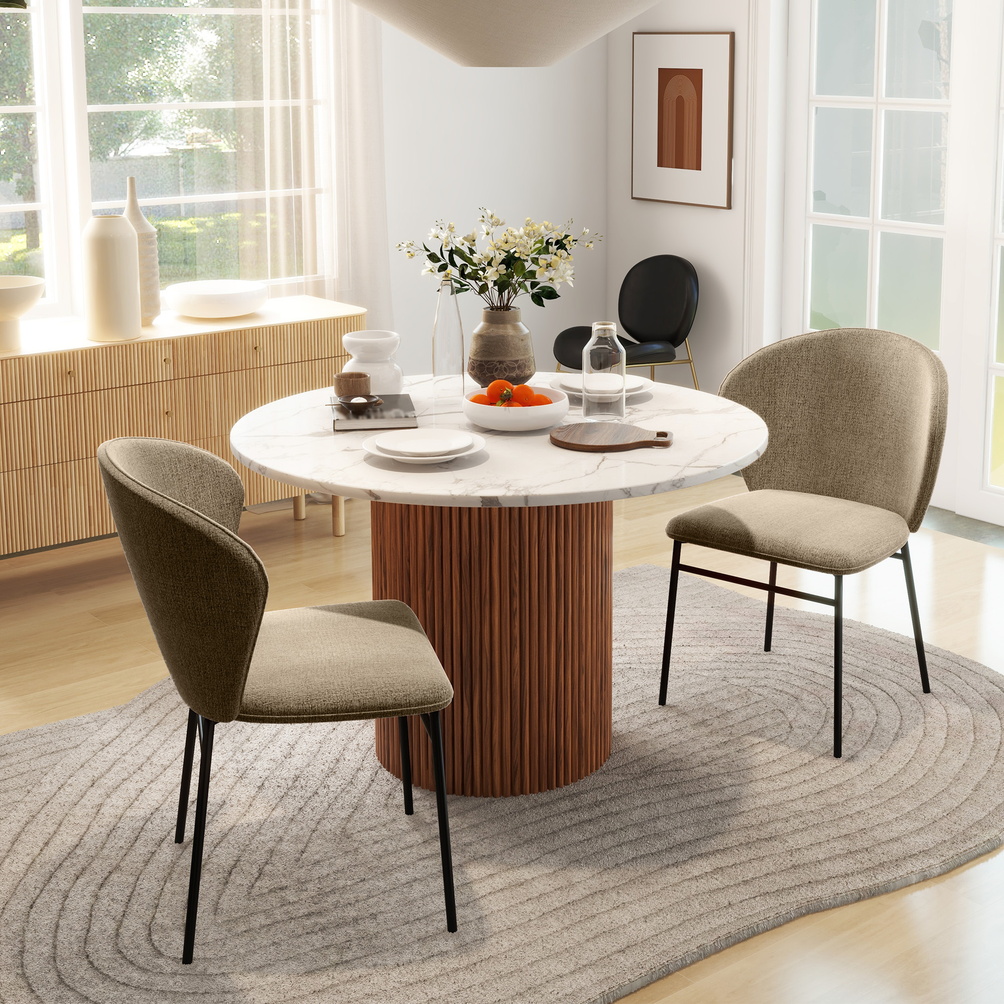 Una luminosa zona pranzo con tavolo rotondo in marmo, due sedie beige e una console in legno sullo sfondo.