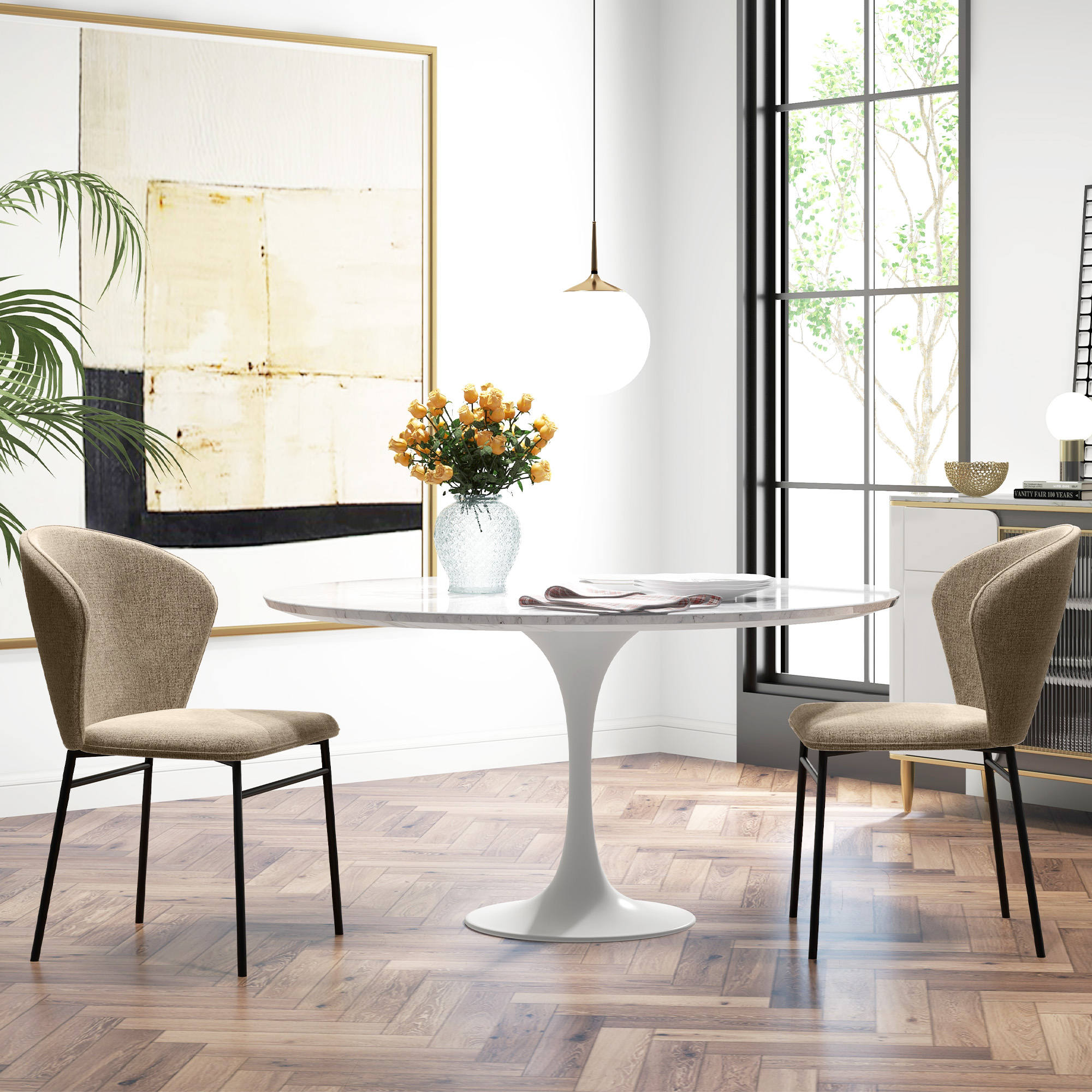 Una luminosa sala da pranzo con un tavolo rotondo bianco, due sedie beige, un vaso di fiori e una grande opera d'arte astratta.