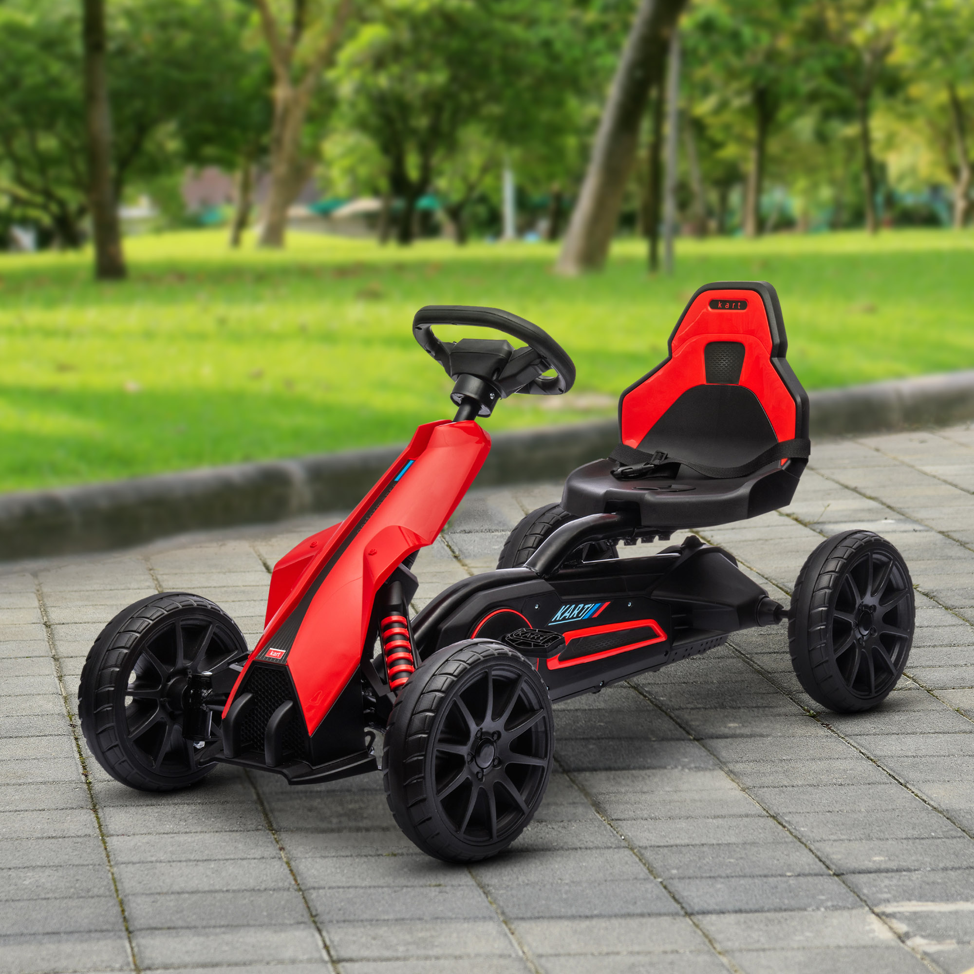 Un go-kart rosso e nero si trova su un sentiero lastricato in un parco con alberi verdi ed erba.