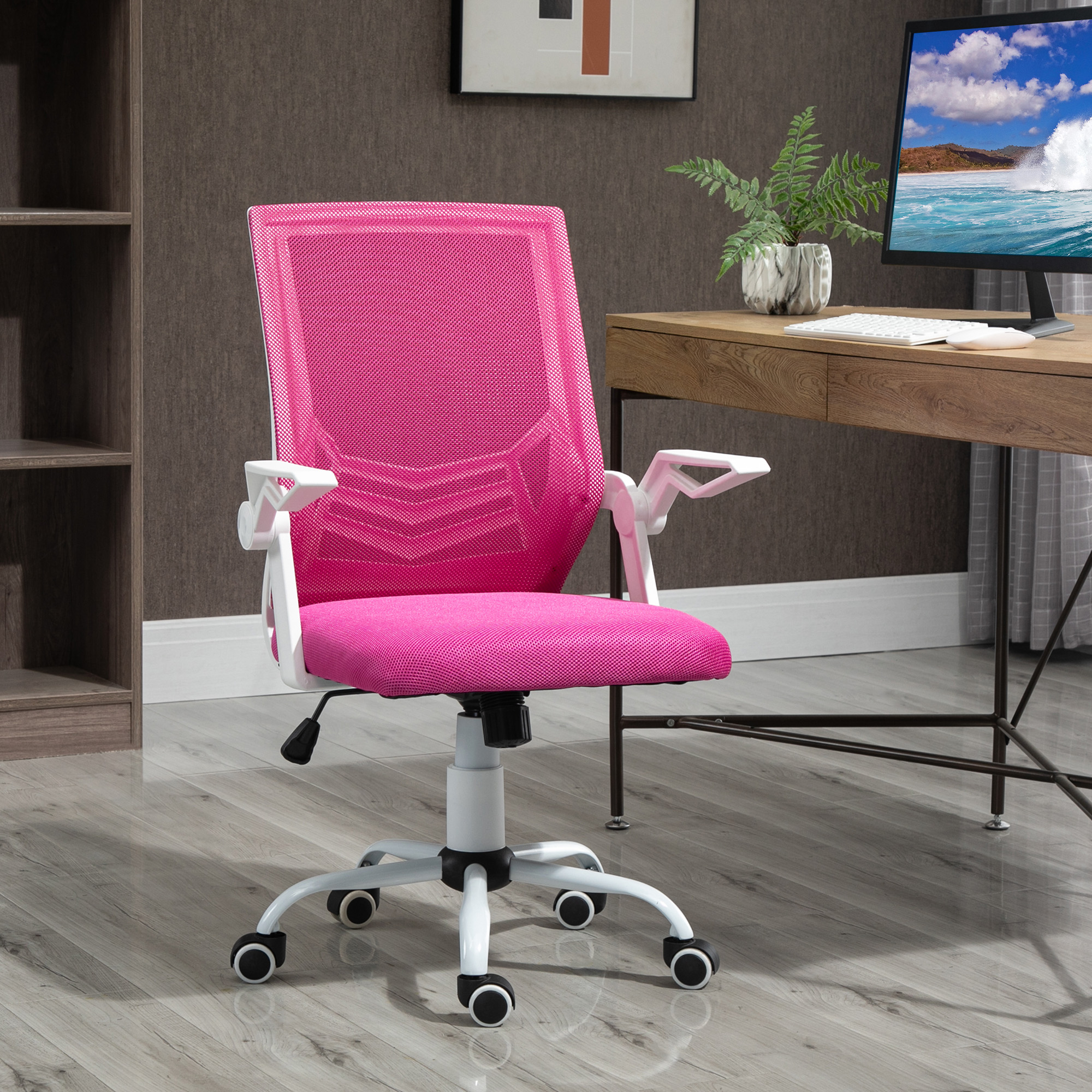 Una sedia da ufficio in rete rosa brillante con struttura e ruote bianche, in una stanza con scrivania in legno.