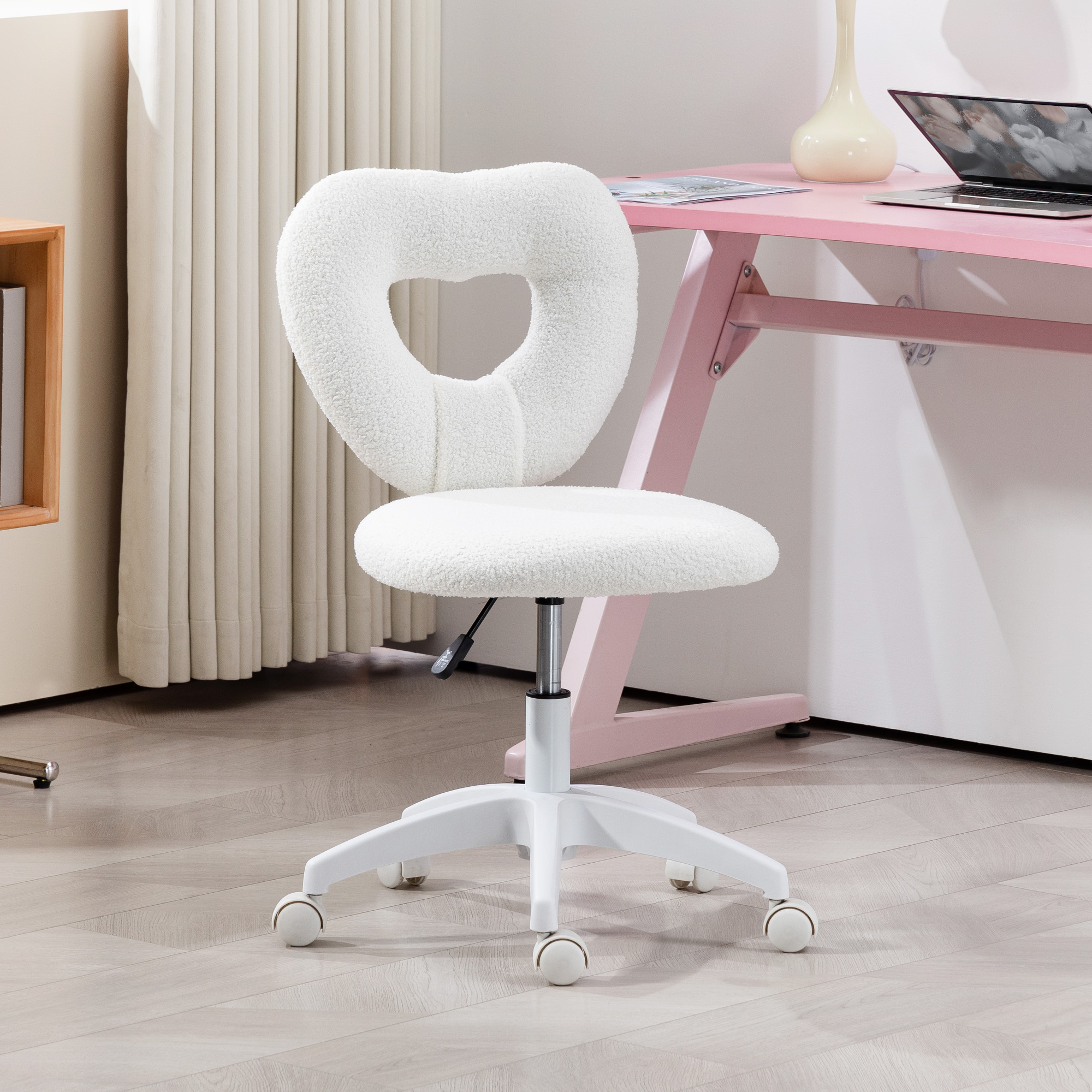 Una sedia girevole bianca pelosa con schienale a forma di cuore davanti a una scrivania rosa.