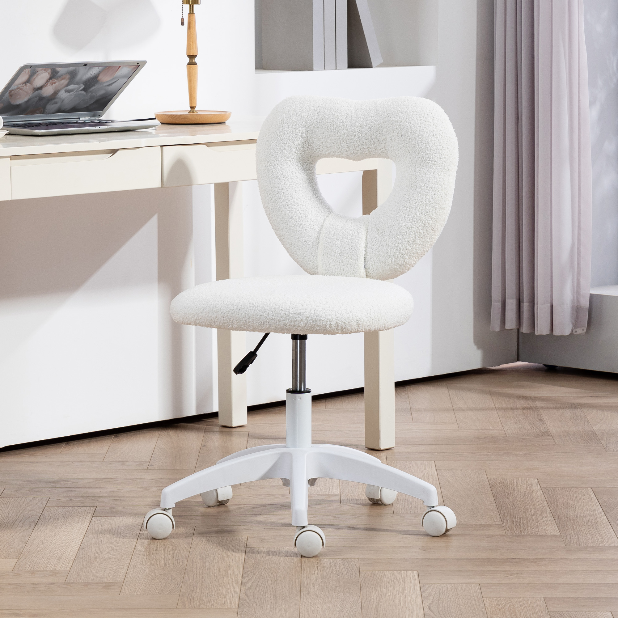 Sedia bianca soffice con schienale a forma di cuore e ruote vicino a una scrivania.