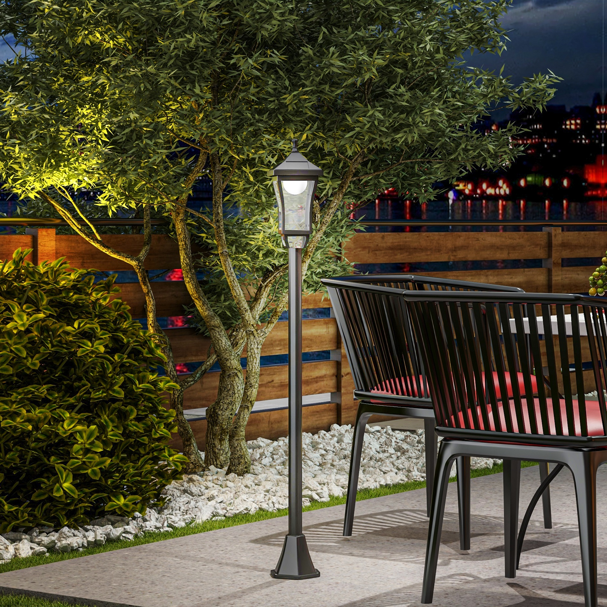 Lampada da giardino illuminata su un patio con sedie e piante verdi di notte.