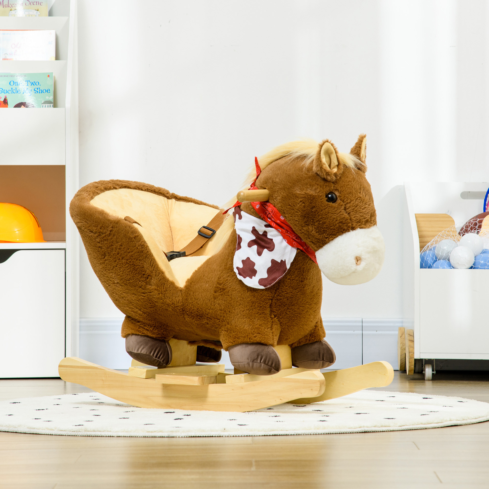 Un cavallo a dondolo di peluche marrone con sedile e bandana rossa su un tappeto bianco in una stanza giochi.