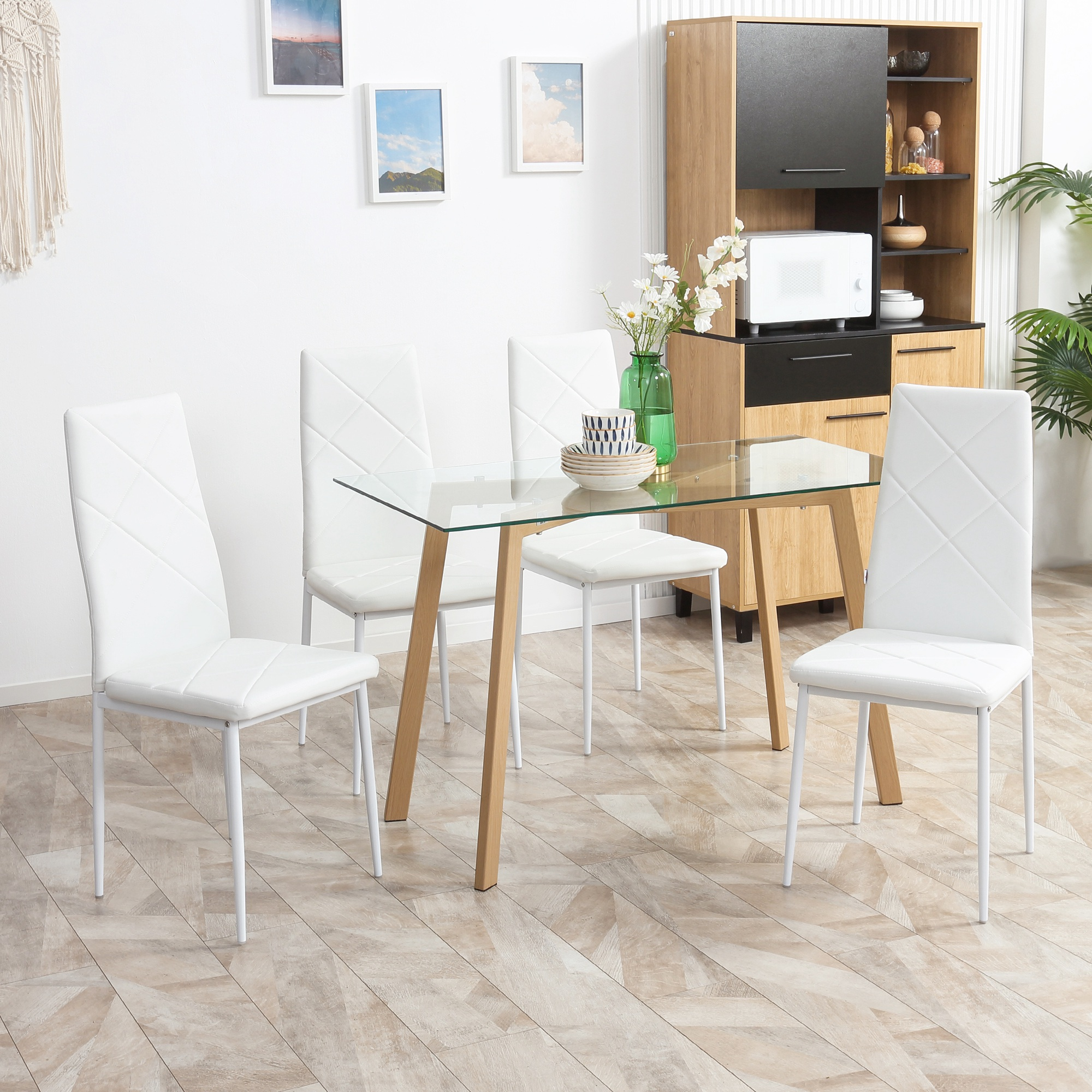 Moderno set da pranzo con tavolo in vetro e quattro sedie bianche.