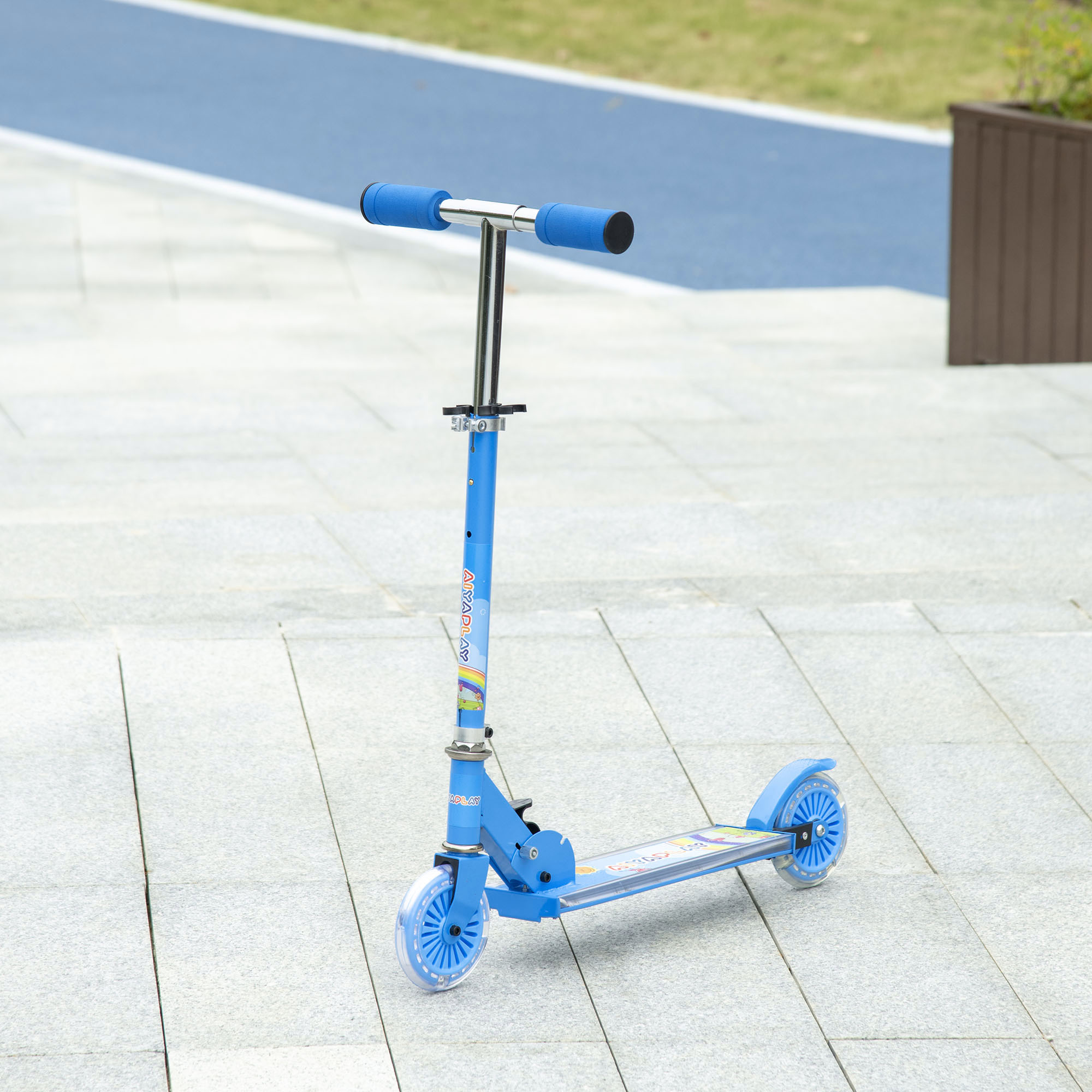 Un monopattino blu su pavimento piastrellato con un percorso blu e una fioriera marrone sullo sfondo.
