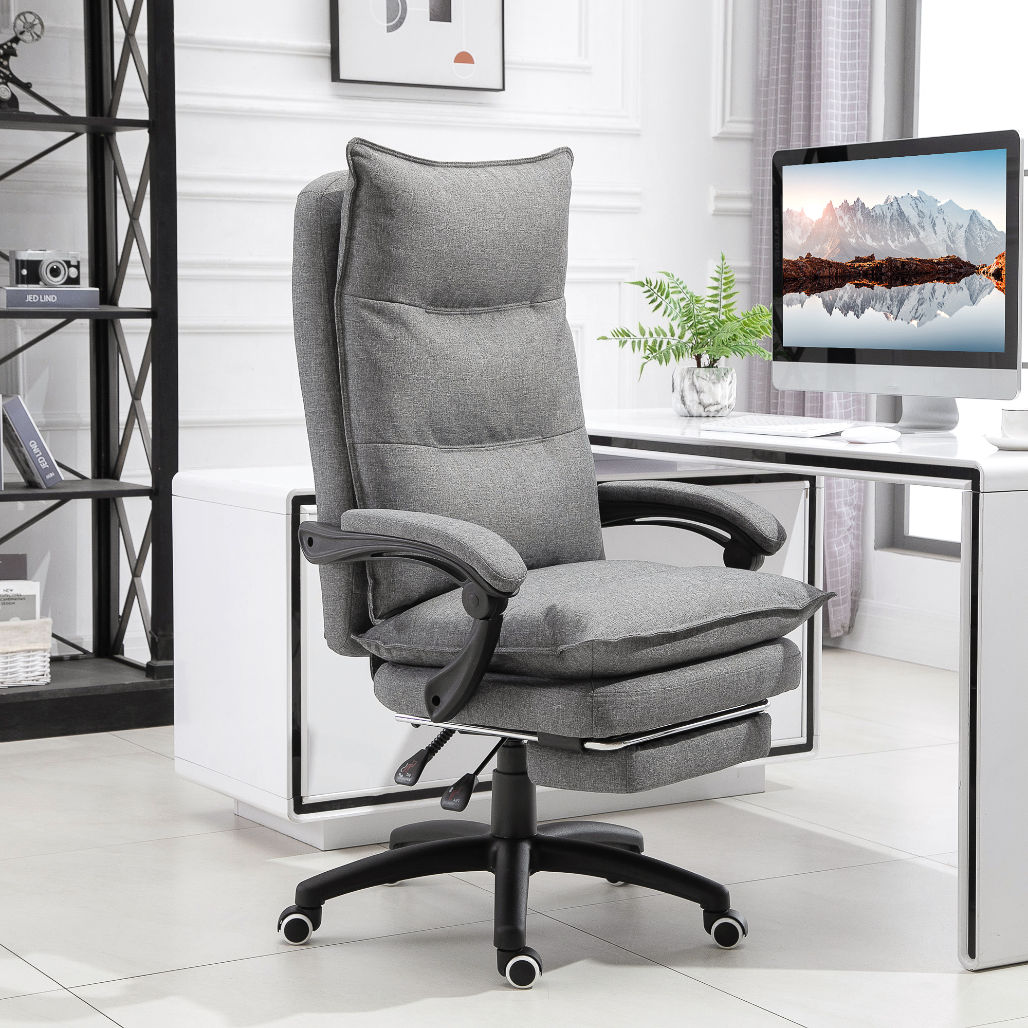 Una sedia da ufficio ergonomica grigia con poggiapiedi estraibile in una stanza luminosa.