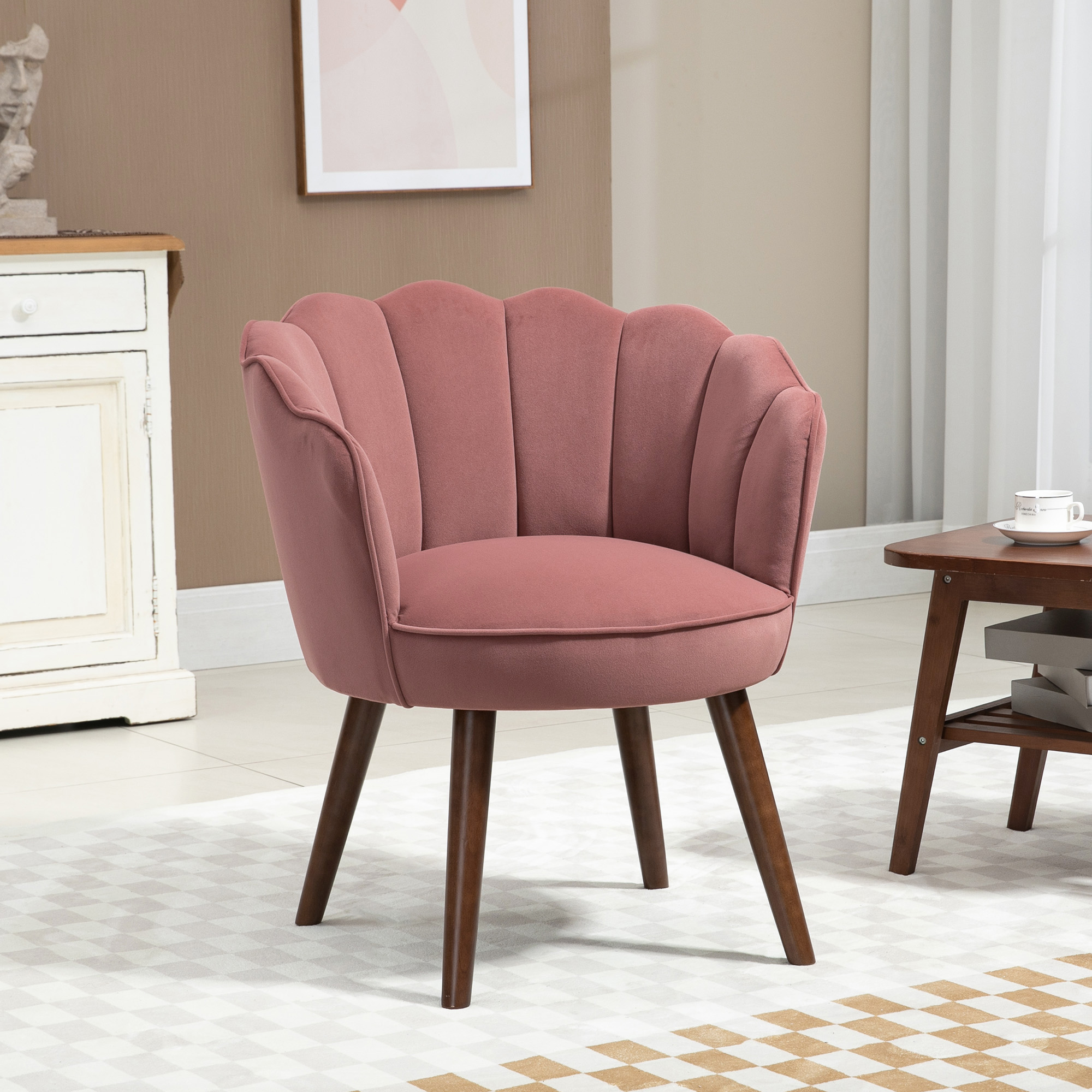 Una poltrona rosa a conchiglia con gambe in legno su un tappeto.