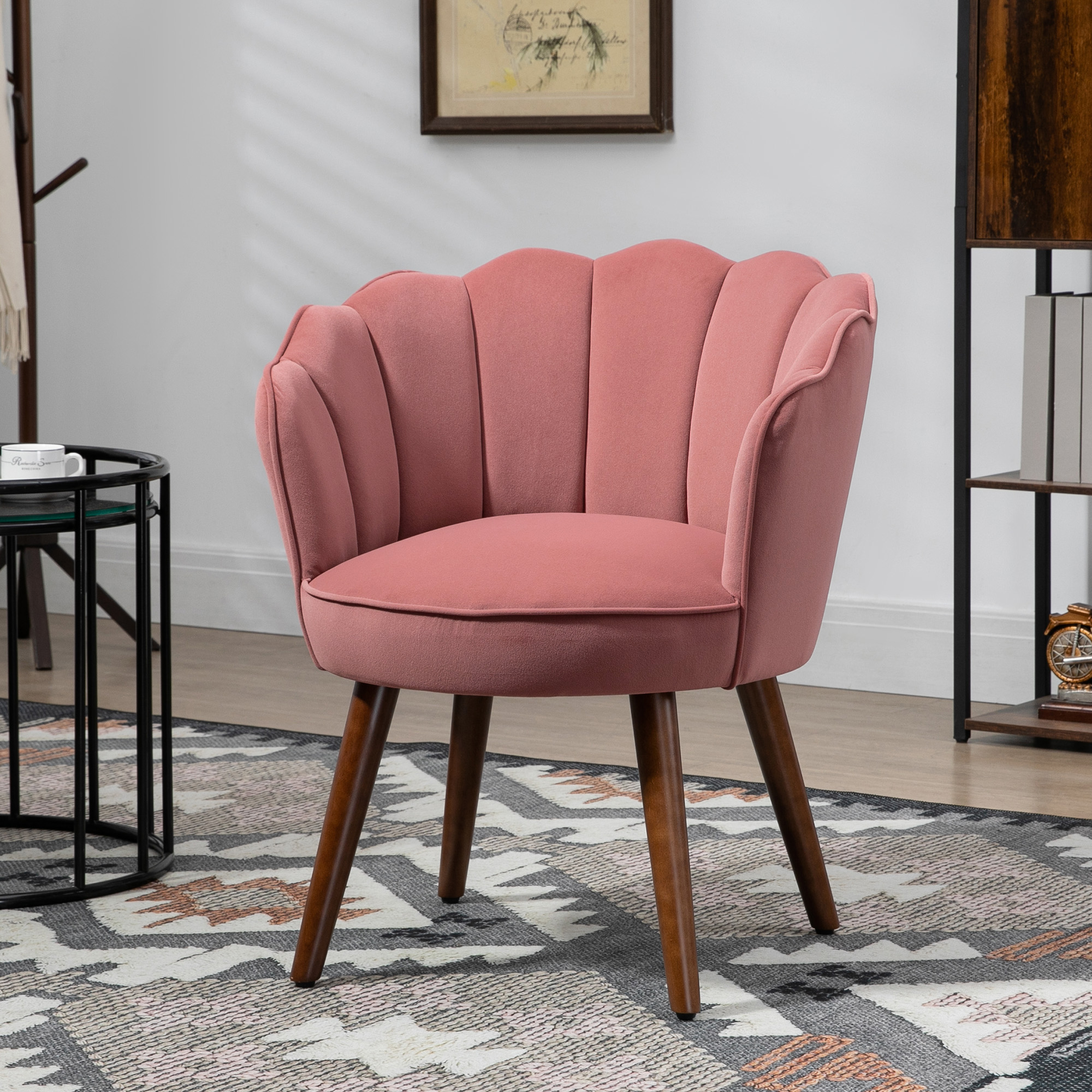 Poltrona in velluto rosa con design a conchiglia e gambe in legno su tappeto.