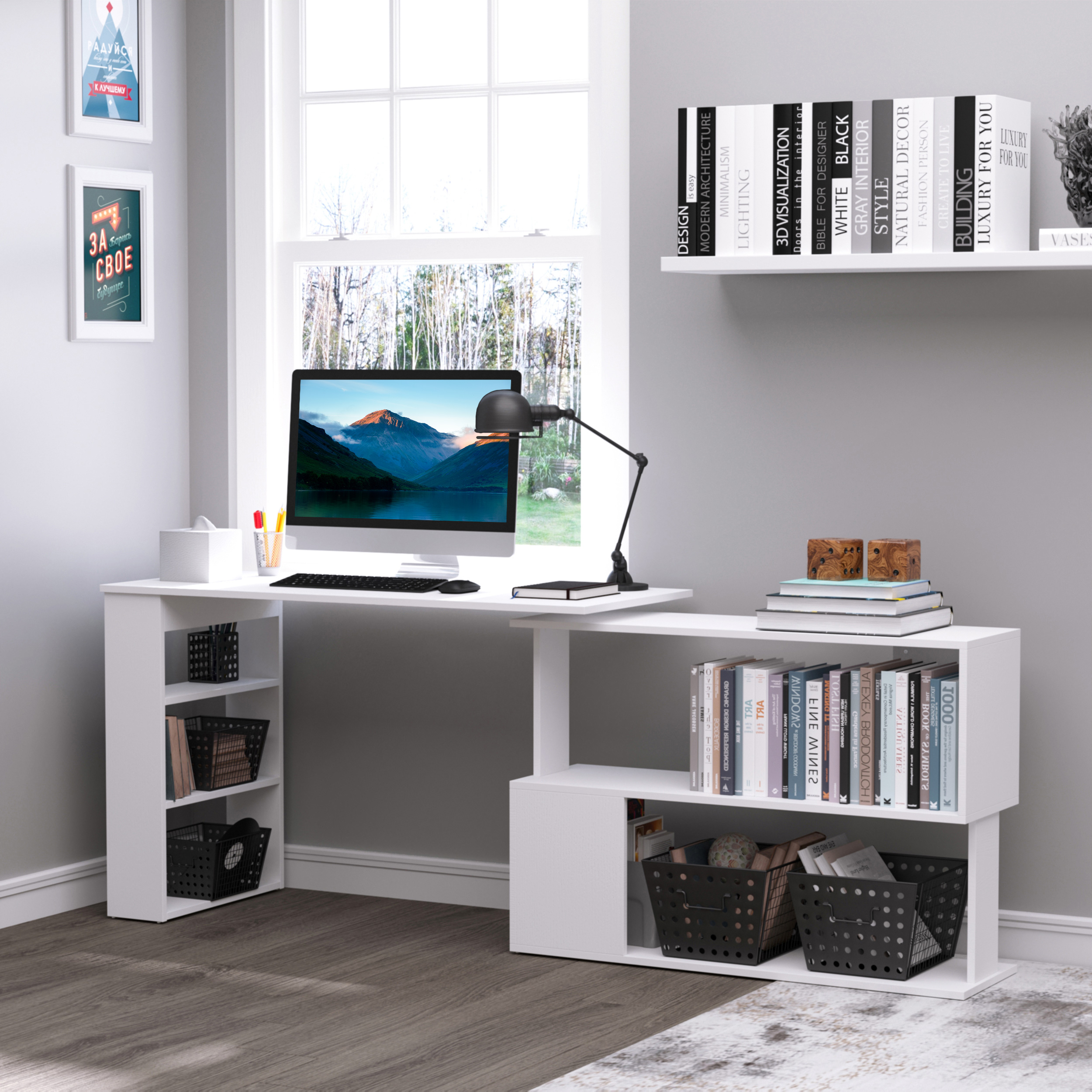 Una scrivania bianca a L con monitor, lampada, libri e cestini portaoggetti in una stanza luminosa.