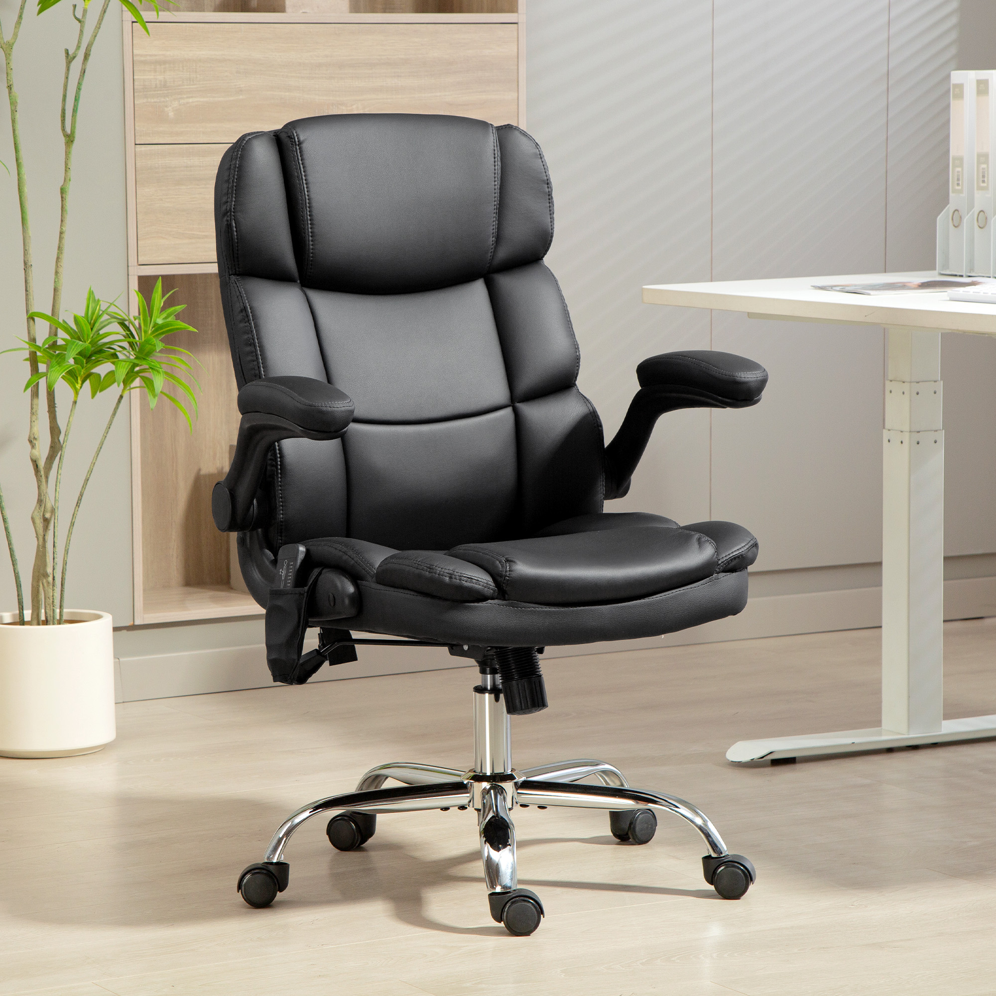 Una sedia da ufficio in pelle nera con base cromata si trova in un ufficio moderno davanti a una scrivania chiara.