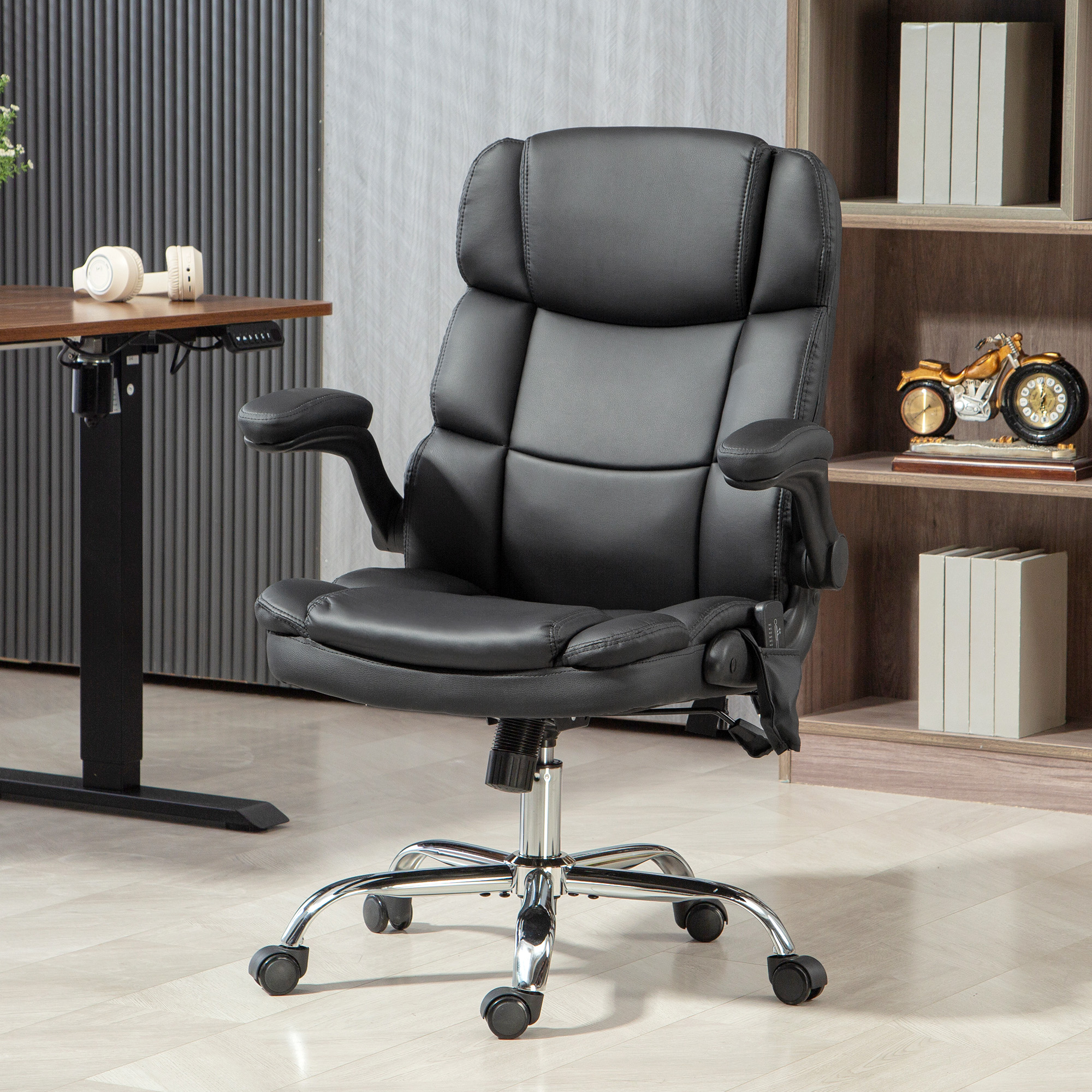Una sedia da ufficio in pelle nera con base cromata si trova in una stanza moderna con libreria e scrivania.