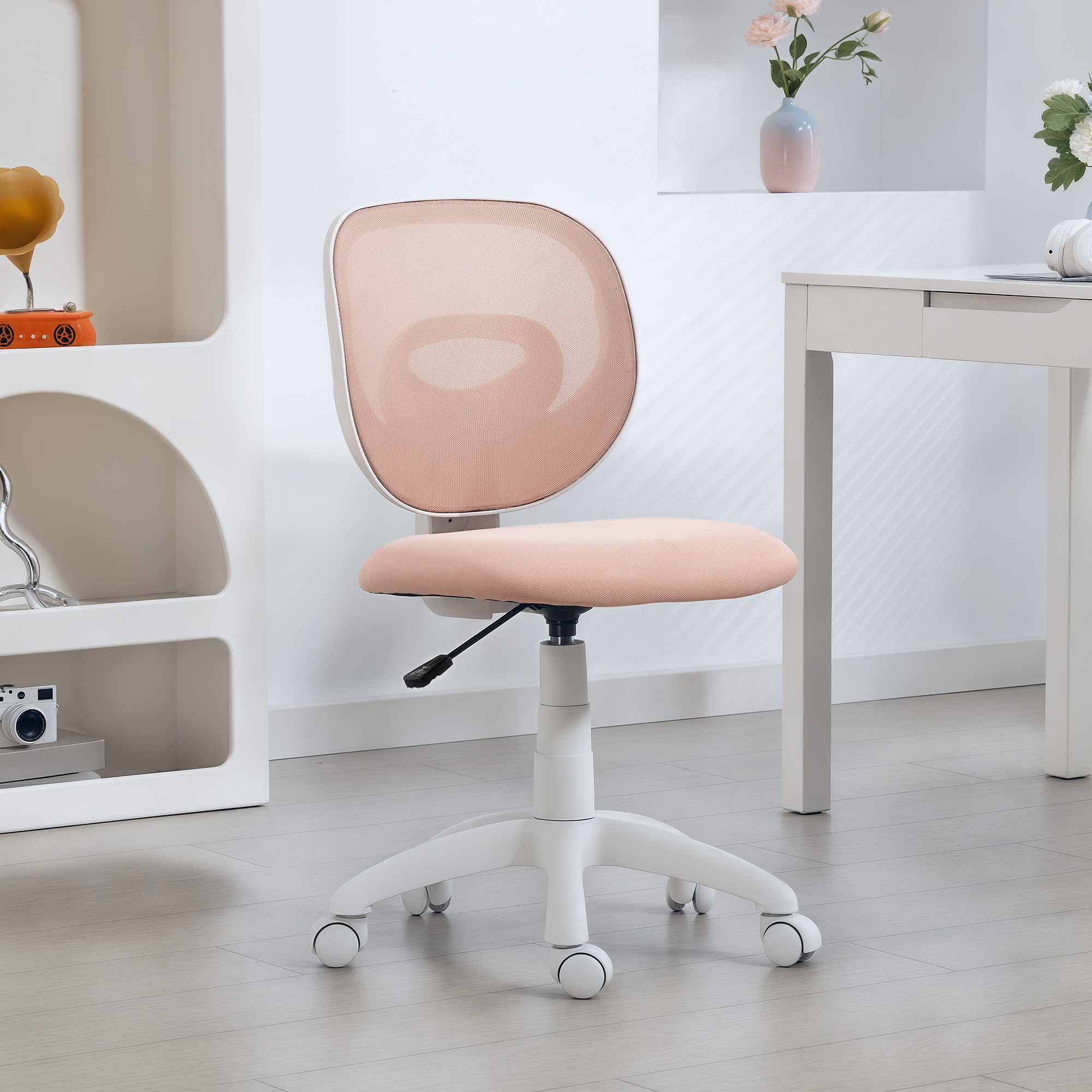 Una sedia da ufficio rosa con base bianca a rotelle, in una stanza luminosa con scrivania e scaffale bianchi.