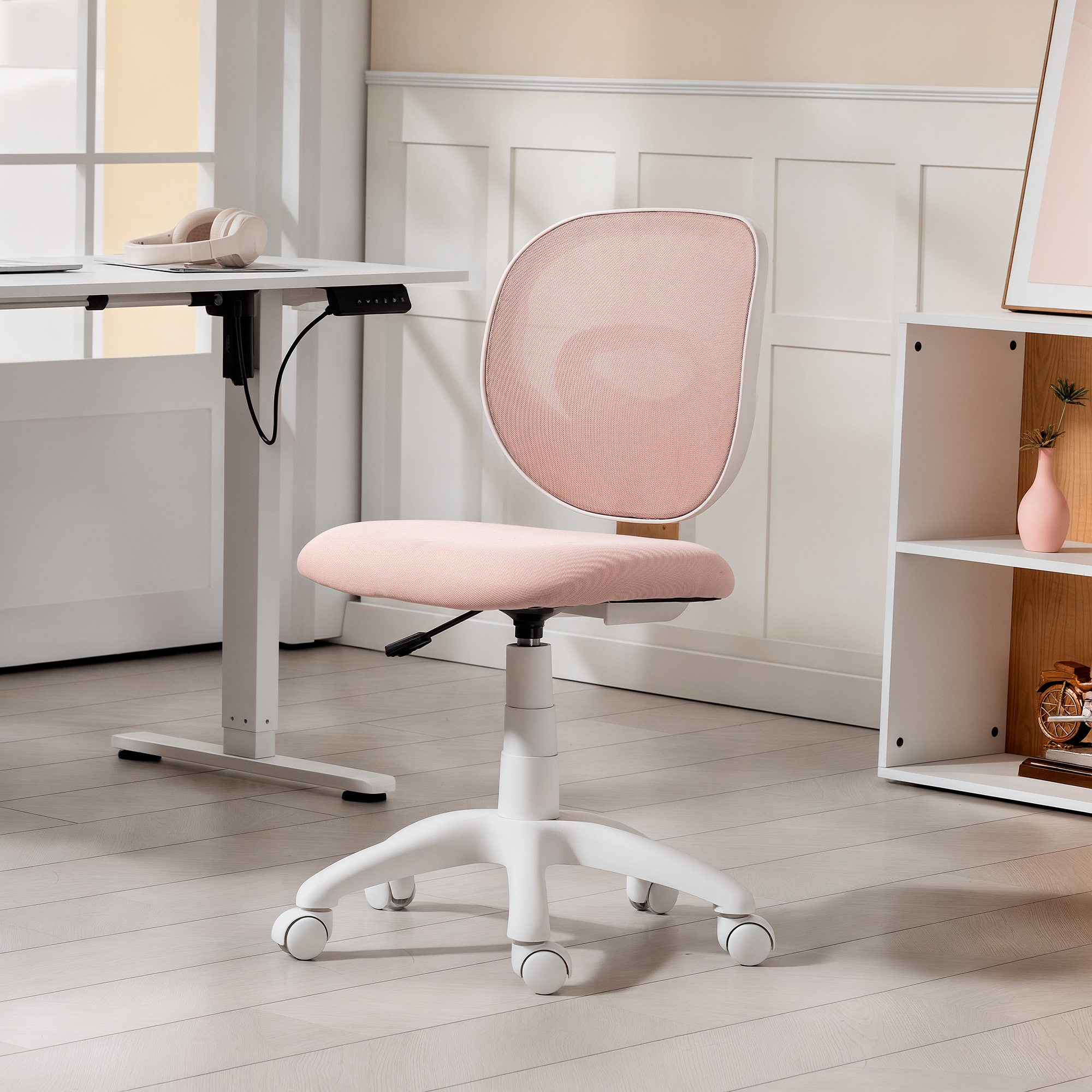 Una sedia da ufficio ergonomica rosa con base bianca e rotelle si trova in una stanza luminosa di fronte a una scrivania.