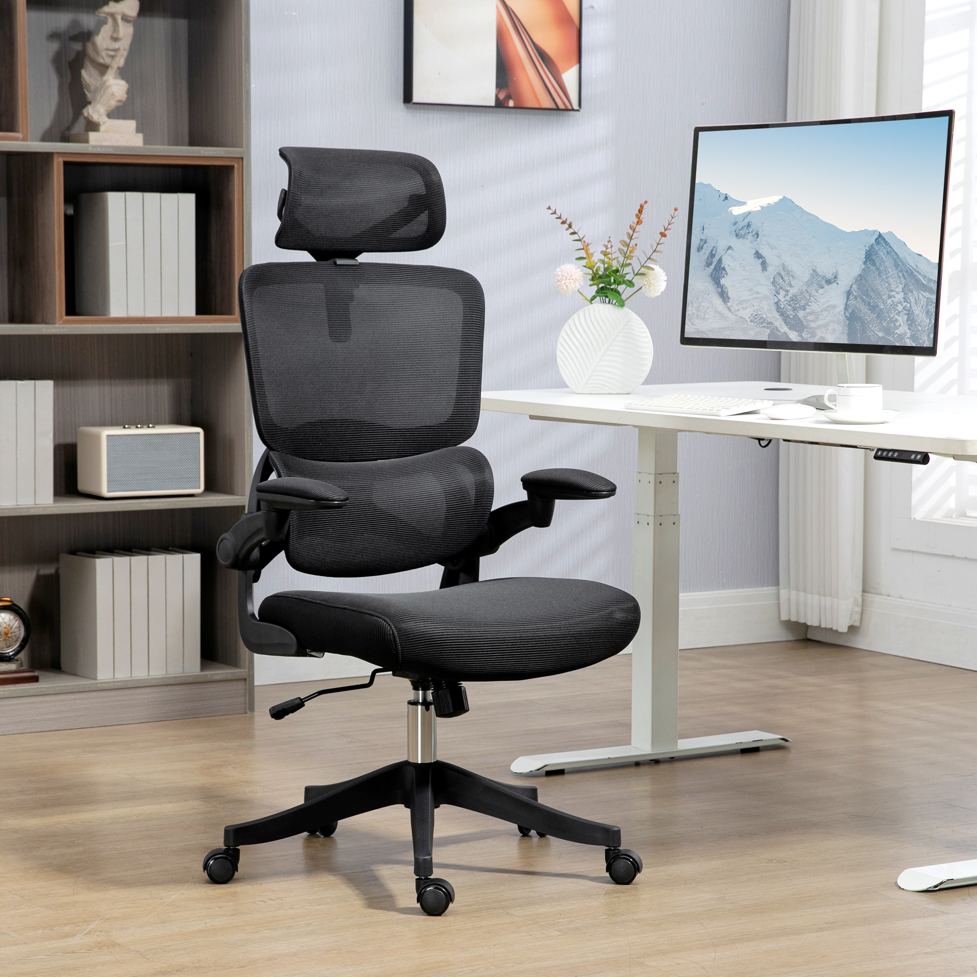Una sedia da ufficchio ergonomica nera si trova in un ufficio moderno davanti a una scrivania bianca.