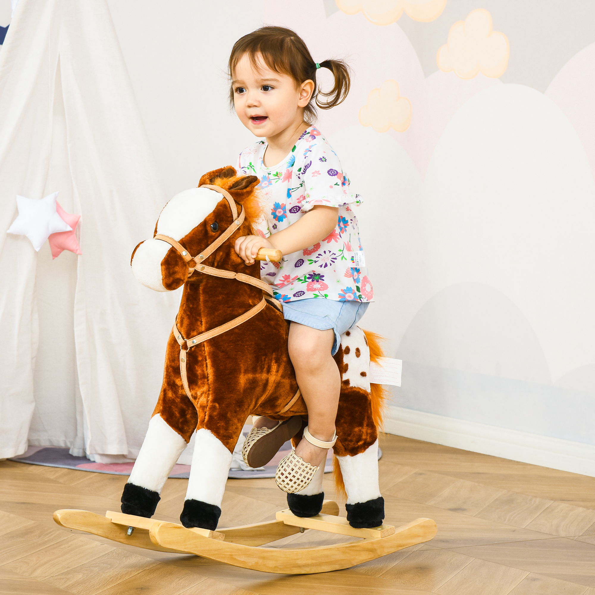Una bambina cavalca un cavallo a dondolo di peluche in una luminosa stanza per bambini.