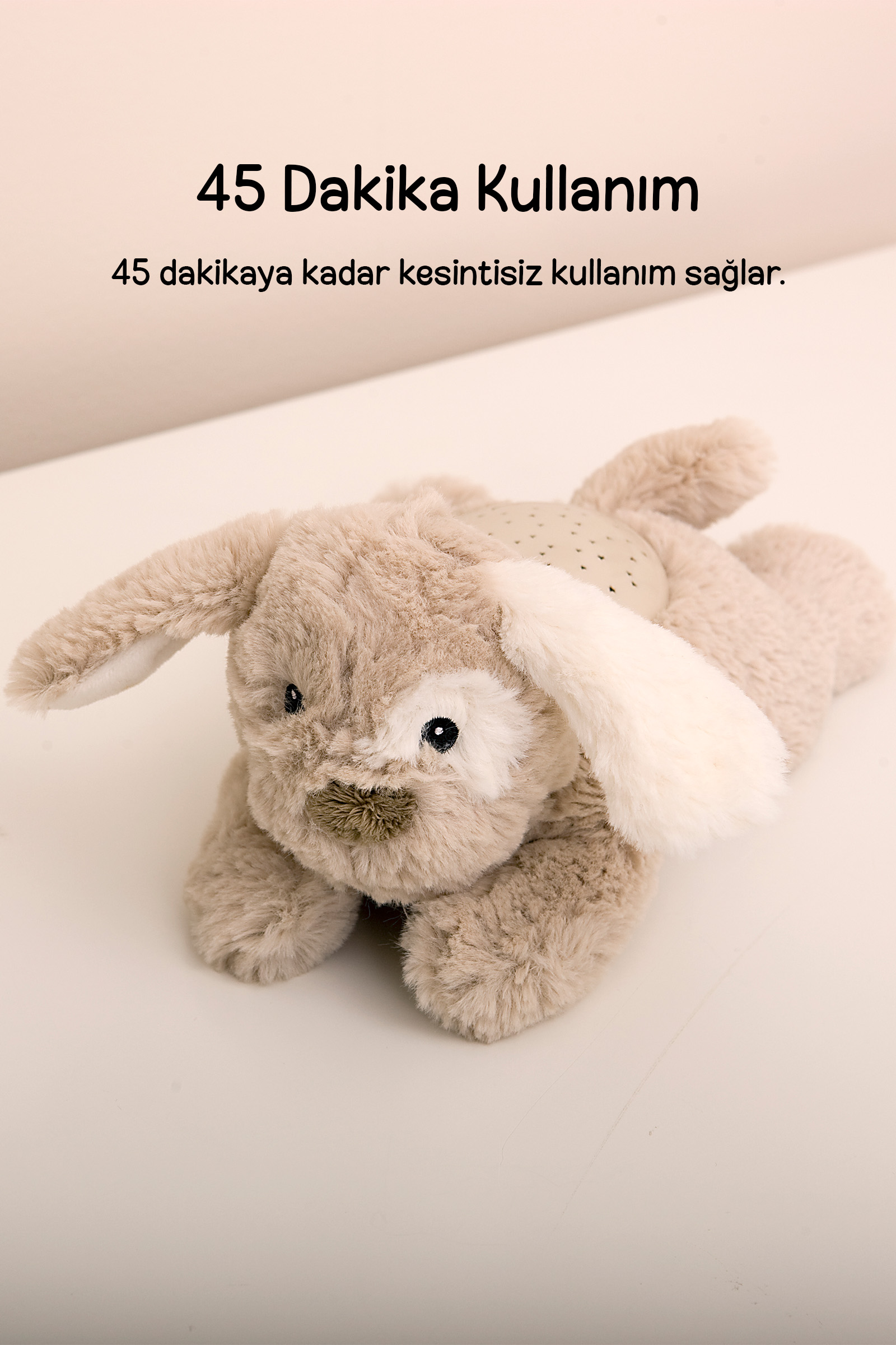Sırtında projektör olan tüylü peluş köpek ve üstte Türkçe yazı.