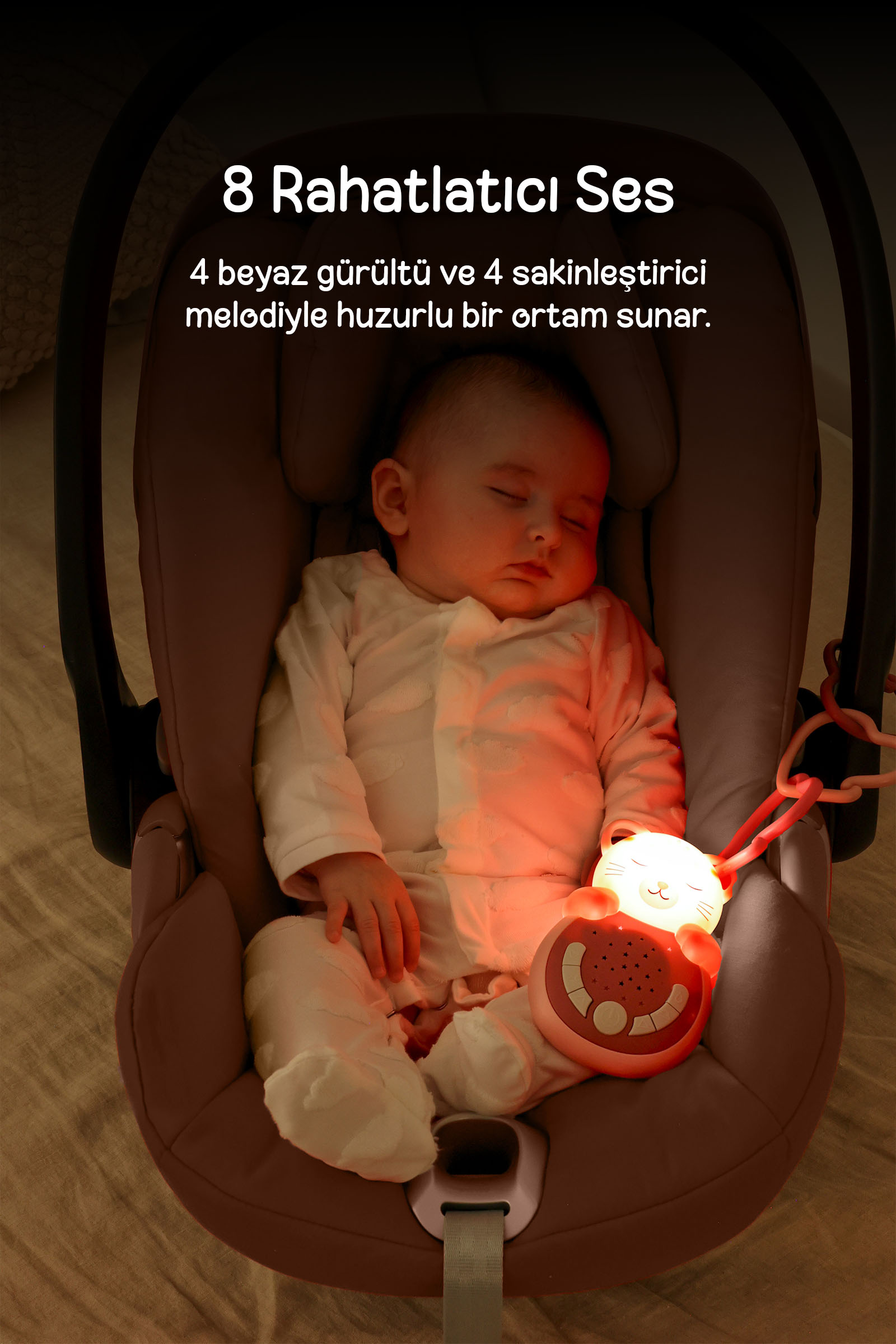 Araba koltuğunda huzurla uyuyan bebek ve yanında parlayan kedi şeklinde ses makinesi, üzerinde Türkçe yazı var.