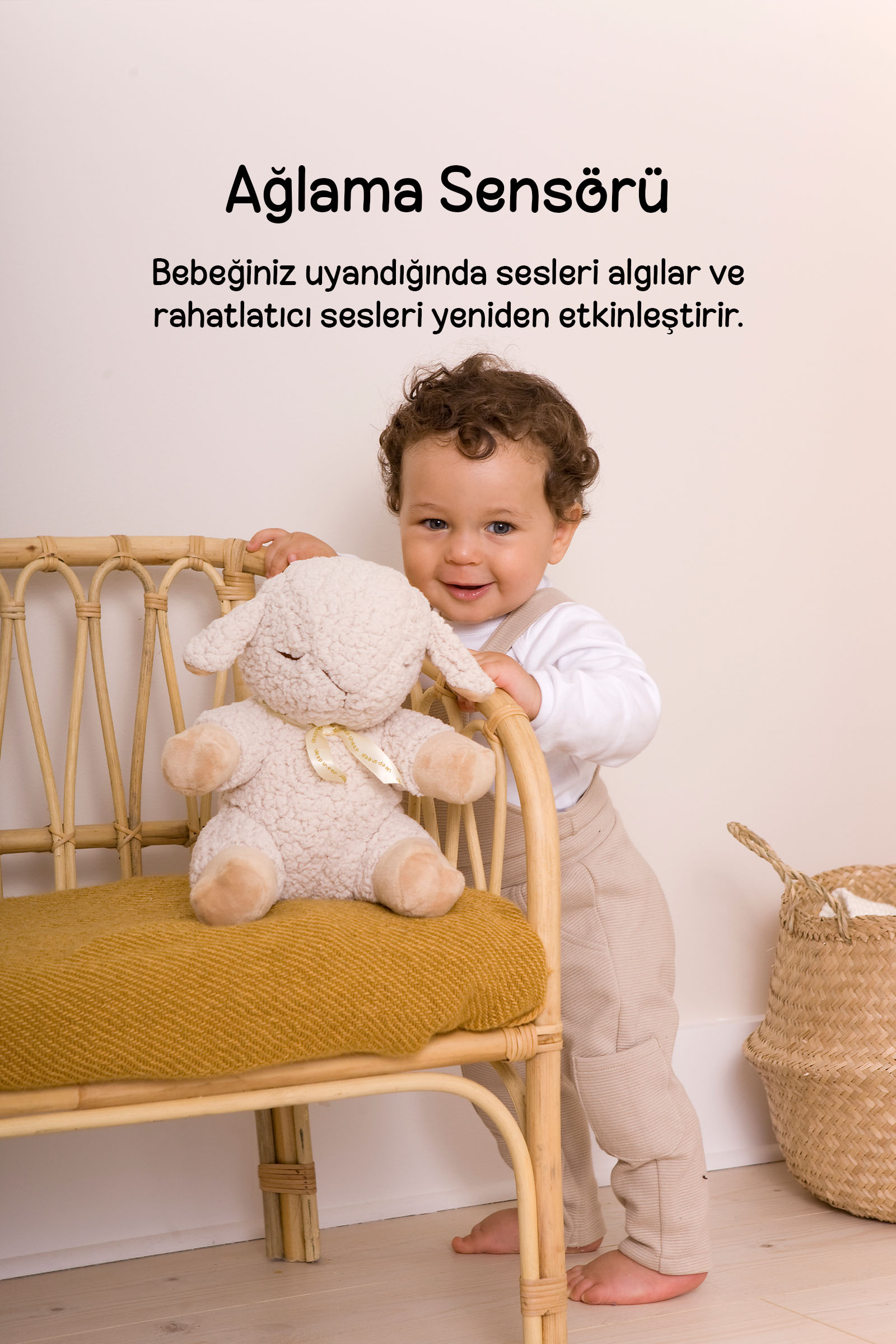 Peluş koyunlu rattan sandalyenin yanında gülümseyen yürümeye başlayan çocuk, sepet.
