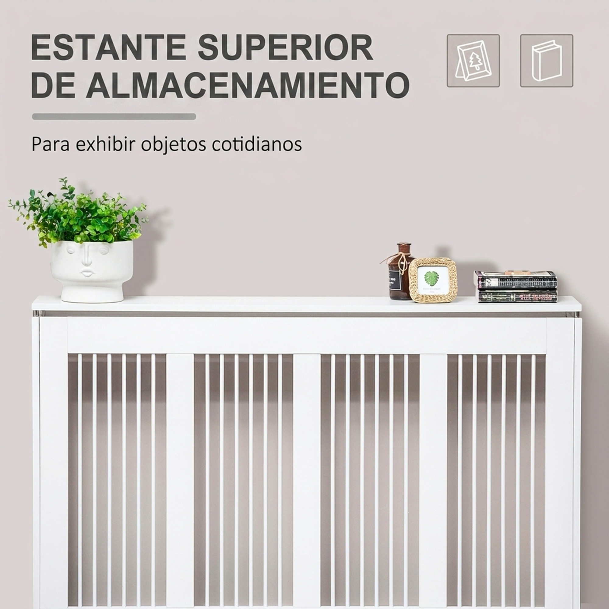 Un cubrerradiador blanco con balda, planta en maceta, un pequeño marco y libros contra una pared gris.