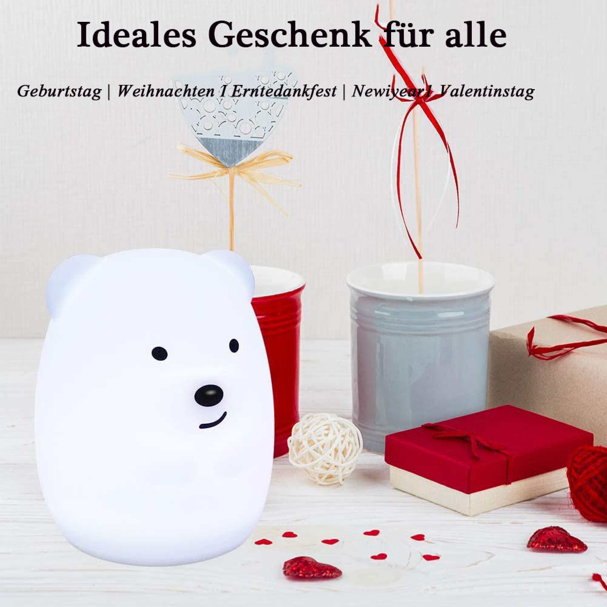 Weißes Bären-Nachtlicht, rote und graue Tassen und Geschenke mit rotem Band.