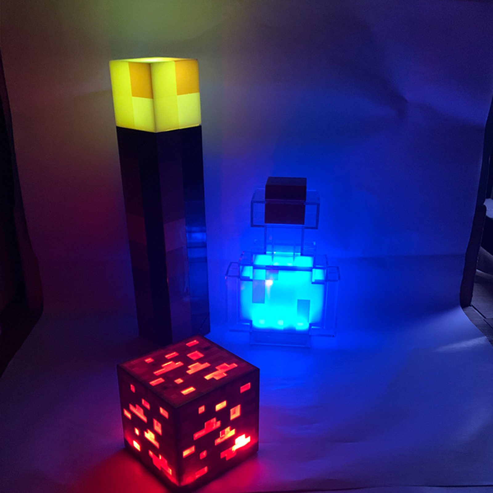 Minecraft-Schreibtischlampen mit gelber Fackel, leuchtend blauer Zaubertrankflasche und rotem Erzblock.