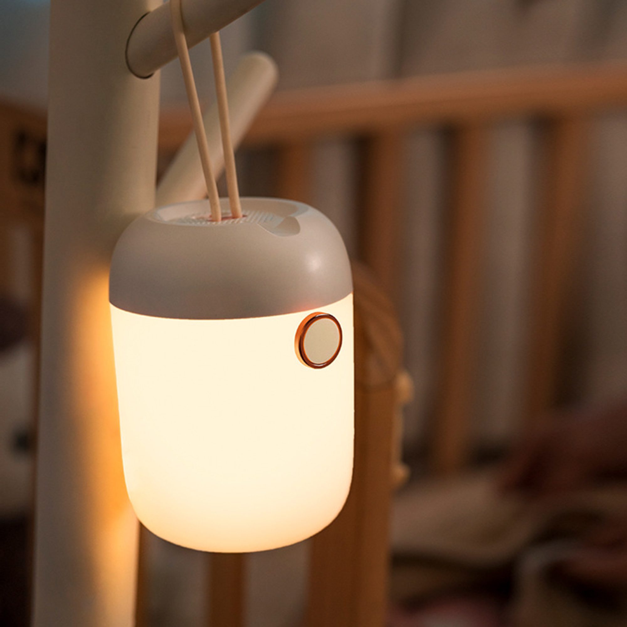 Eine kleine weiße Nachtlampe hängt an einer Stange und strahlt ein warmes Licht aus.