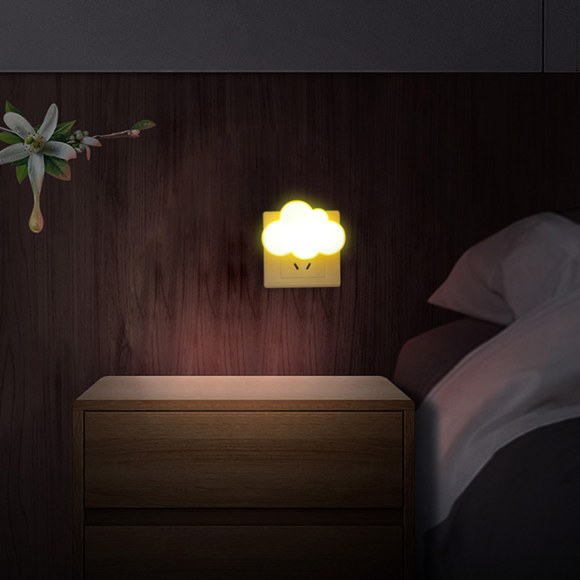 Eine leuchtende wolkenförmige Nachtlampe an einer holzverkleideten Wand über einem Nachttisch.