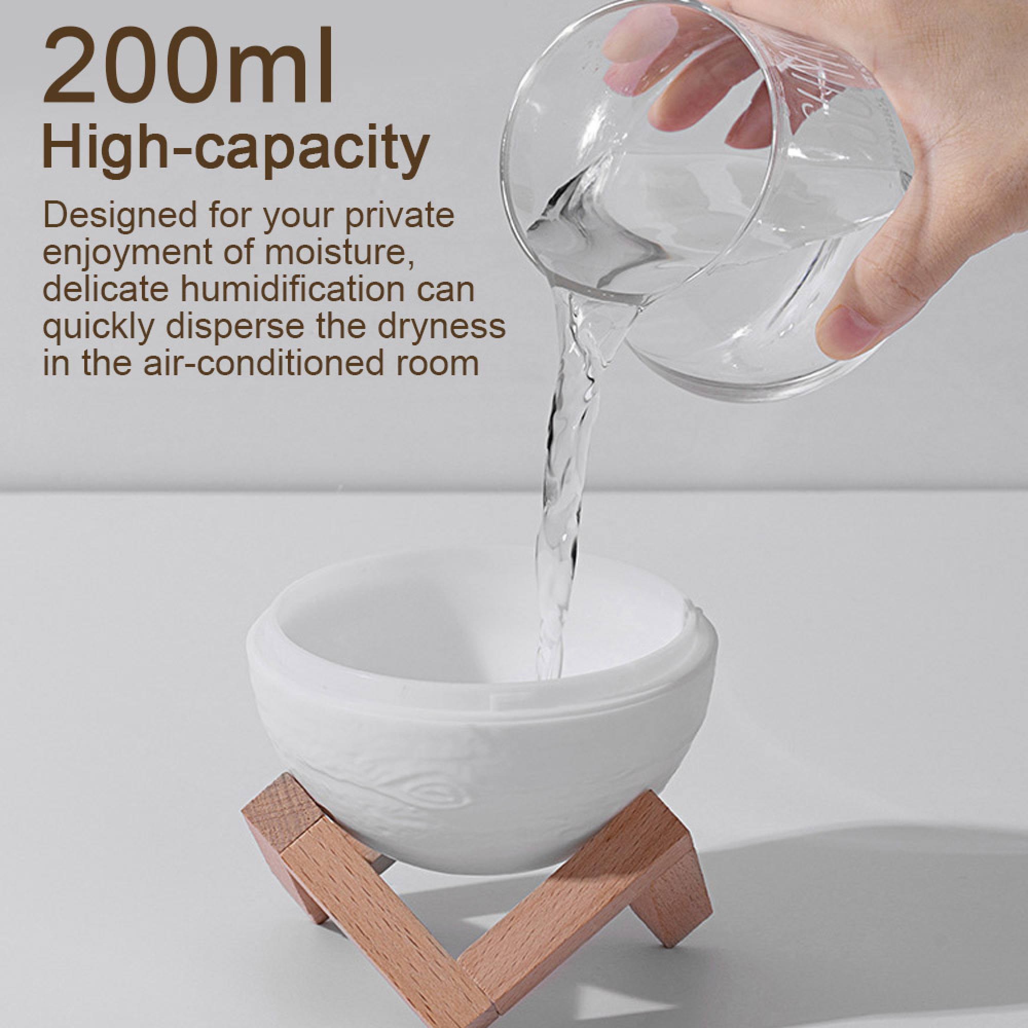 Hand gießt Wasser aus einem Glas in eine weiße Schüssel auf einem Holzständer.
