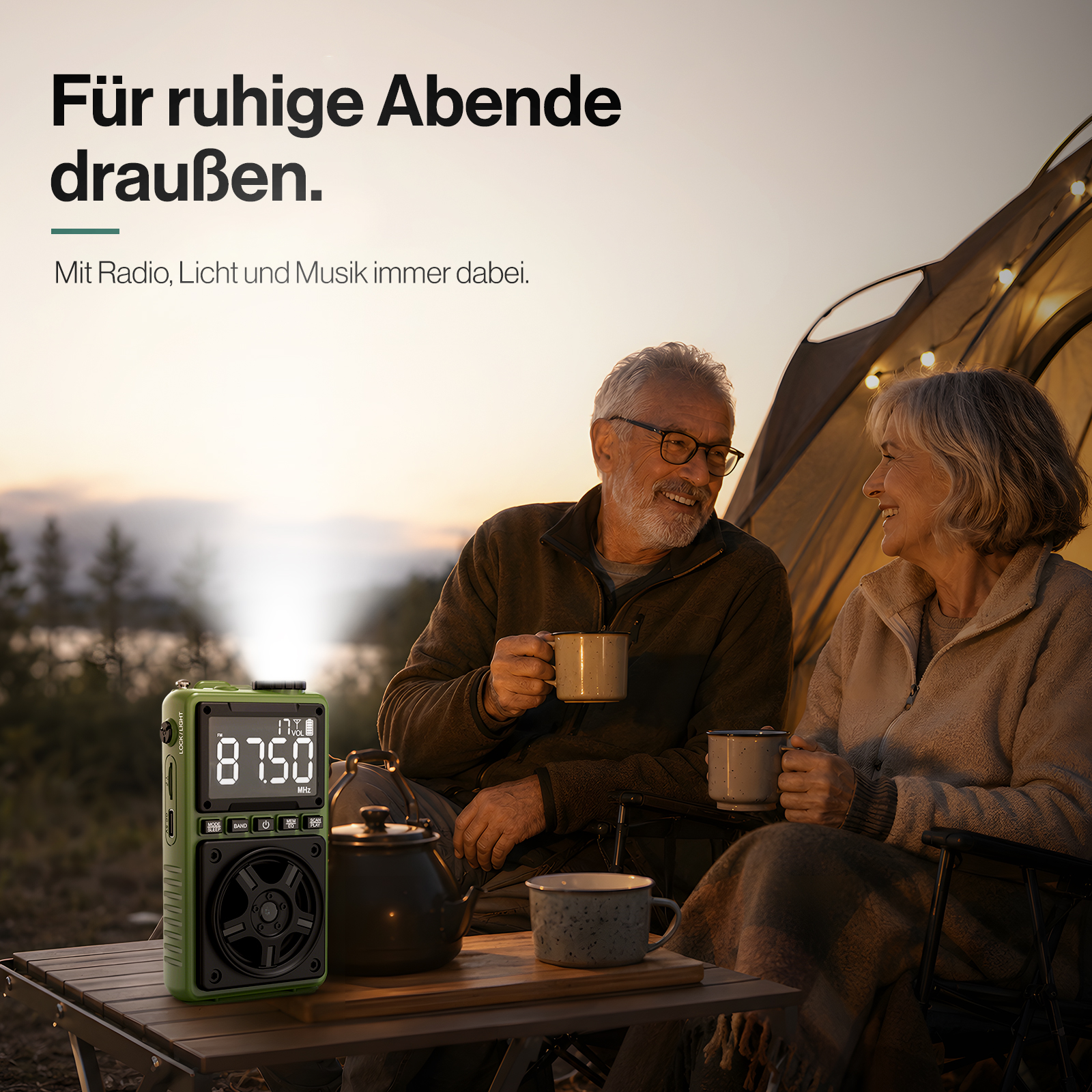 Älteres Paar trinkt Kaffee vor einem Zelt bei Sonnenuntergang, links ein grünes Notfallradio mit Lampe.