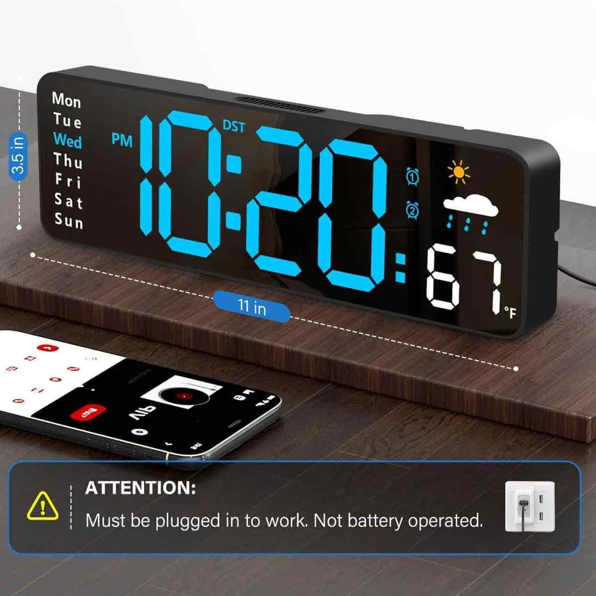 Digitale LED-Uhr mit blauem Display auf Holzoberfläche, daneben ein Smartphone.