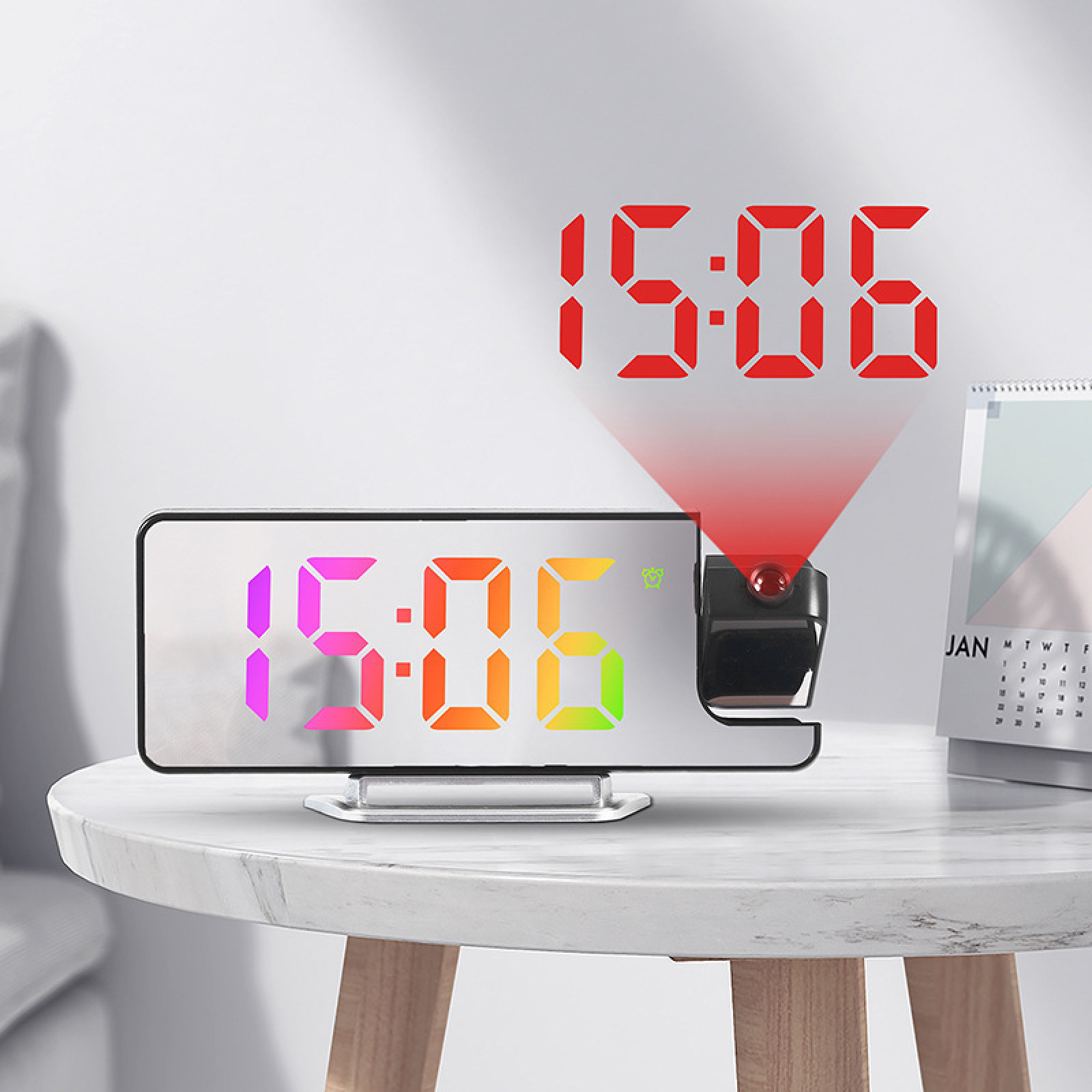Digitale Projektionsuhr mit buntem Display auf einem Holztisch, im Hintergrund ein Kalender.