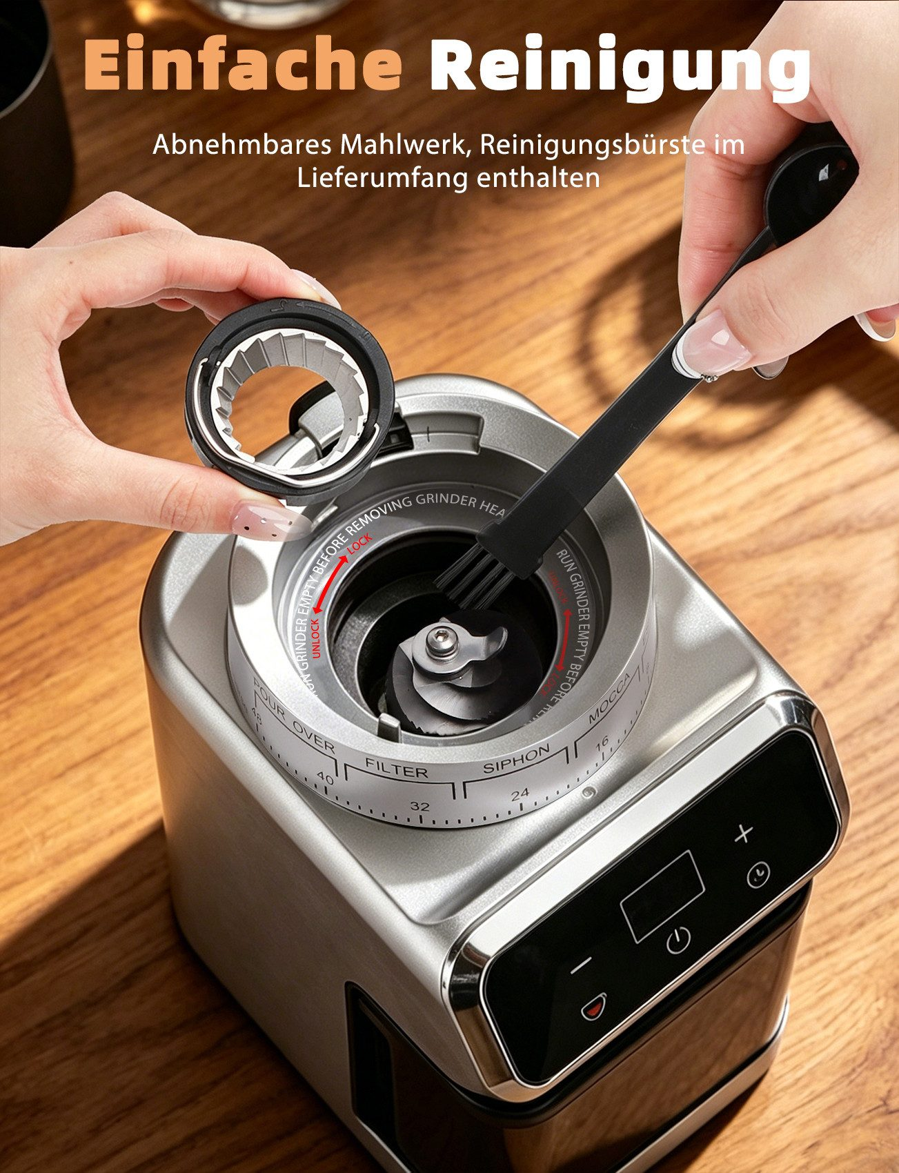 Hände reinigen eine silberne Kaffeemühle mit einer Bürste und entfernen ein Teil.
