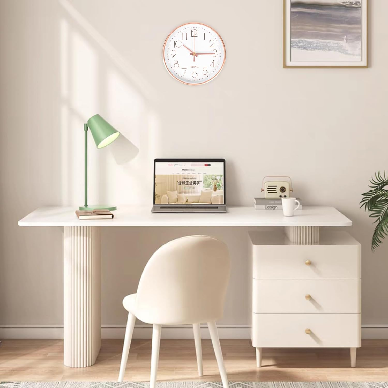 Moderner heller Schreibtisch mit Laptop, Lampe, Stuhl und Wanduhr in einem Raum.