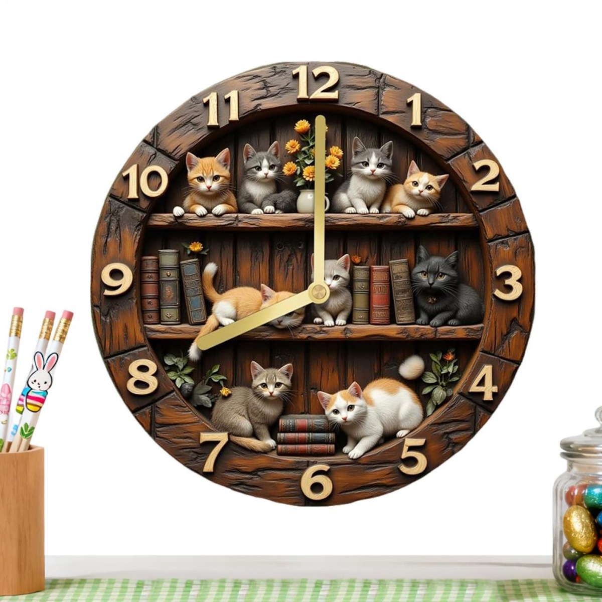 Eine hölzerne Wanduhr mit Regalen voller kleiner Katzen, Büchern und goldenen Zeigern auf weißem Hintergrund.