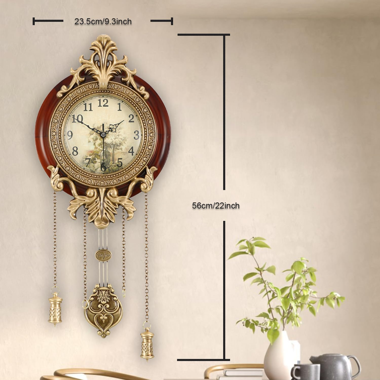 Eine dekorative Wanduhr aus Holz und Gold mit Pendel und Messgewichten hängt an einer beigefarbenen Wand.