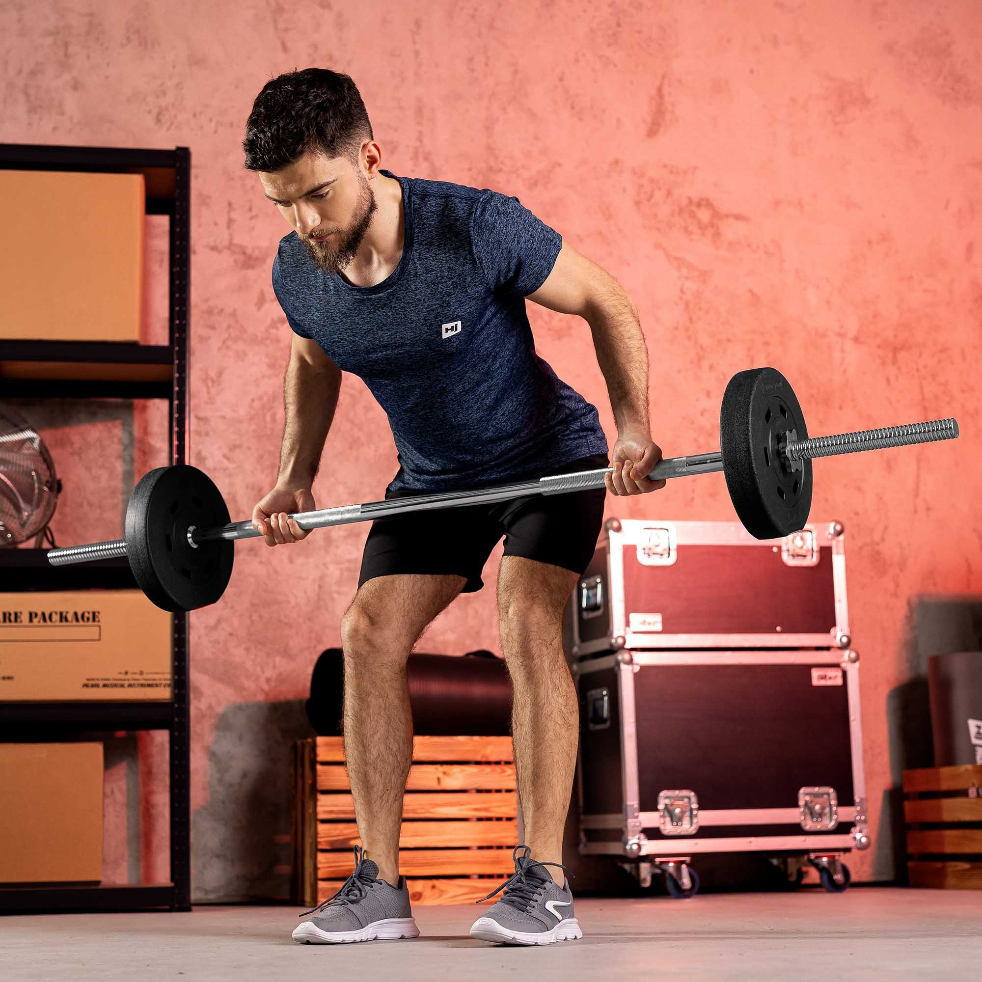 Ein Mann im blauen T-Shirt macht eine Langhantel-Rudern-Übung in einem Fitnessstudio.