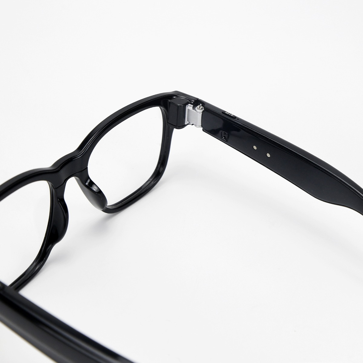 Nahaufnahme des Scharniers und dicken Rahmens schwarzer Smart Glasses auf weißem Hintergrund.