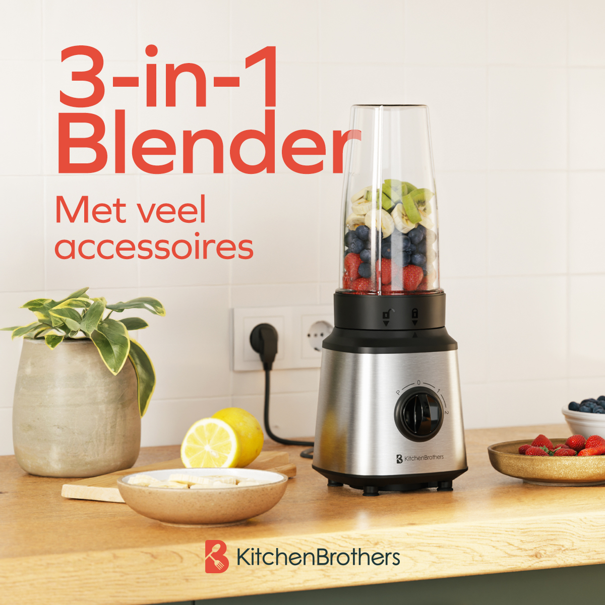Ein silberner 3-in-1-Mixer gefüllt mit Beeren und Bananen steht auf einer Küchentheke neben Früchten und einer Pflanze.