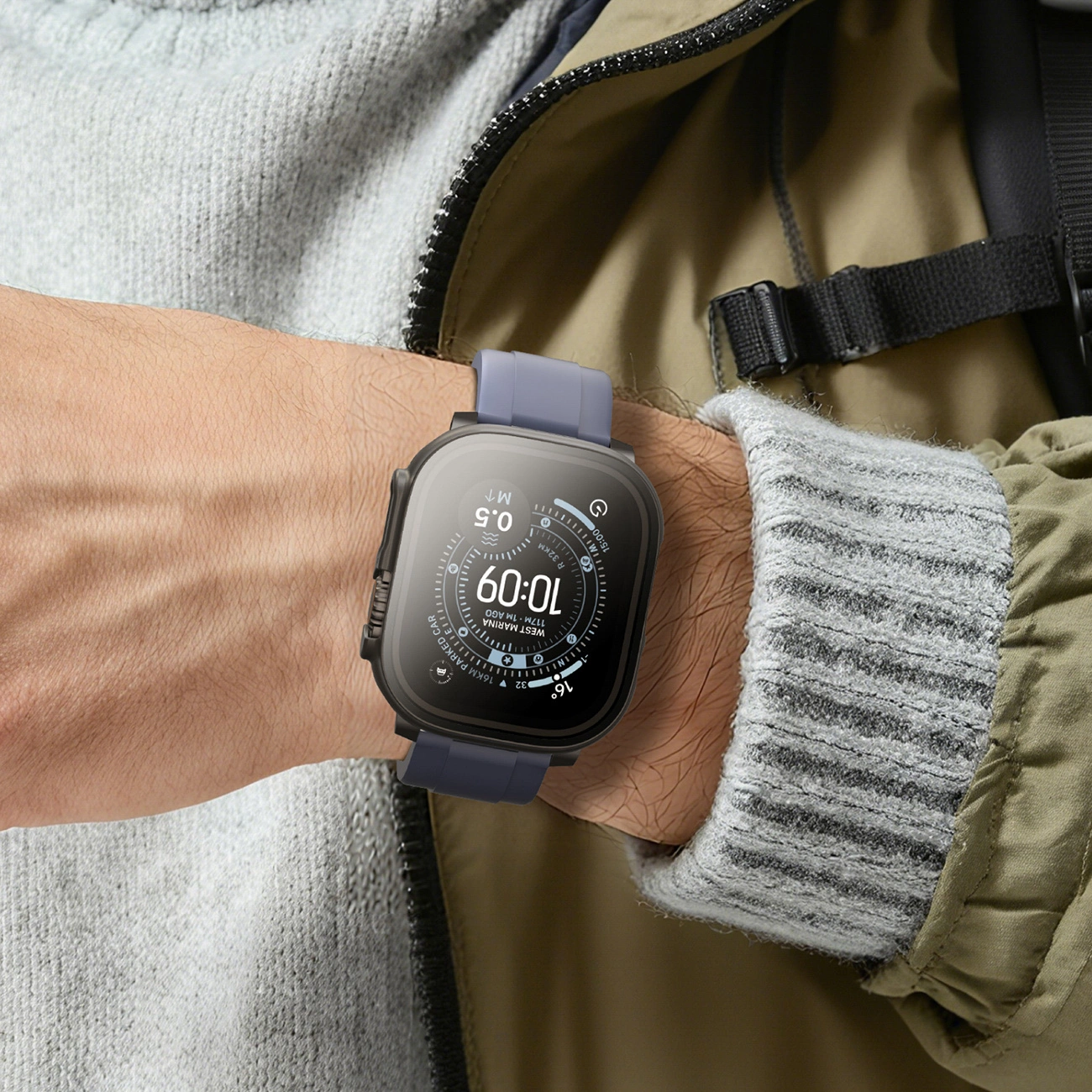 Uno smartwatch con cinturino grigio e display digitale al polso di una persona davanti a una giacca.