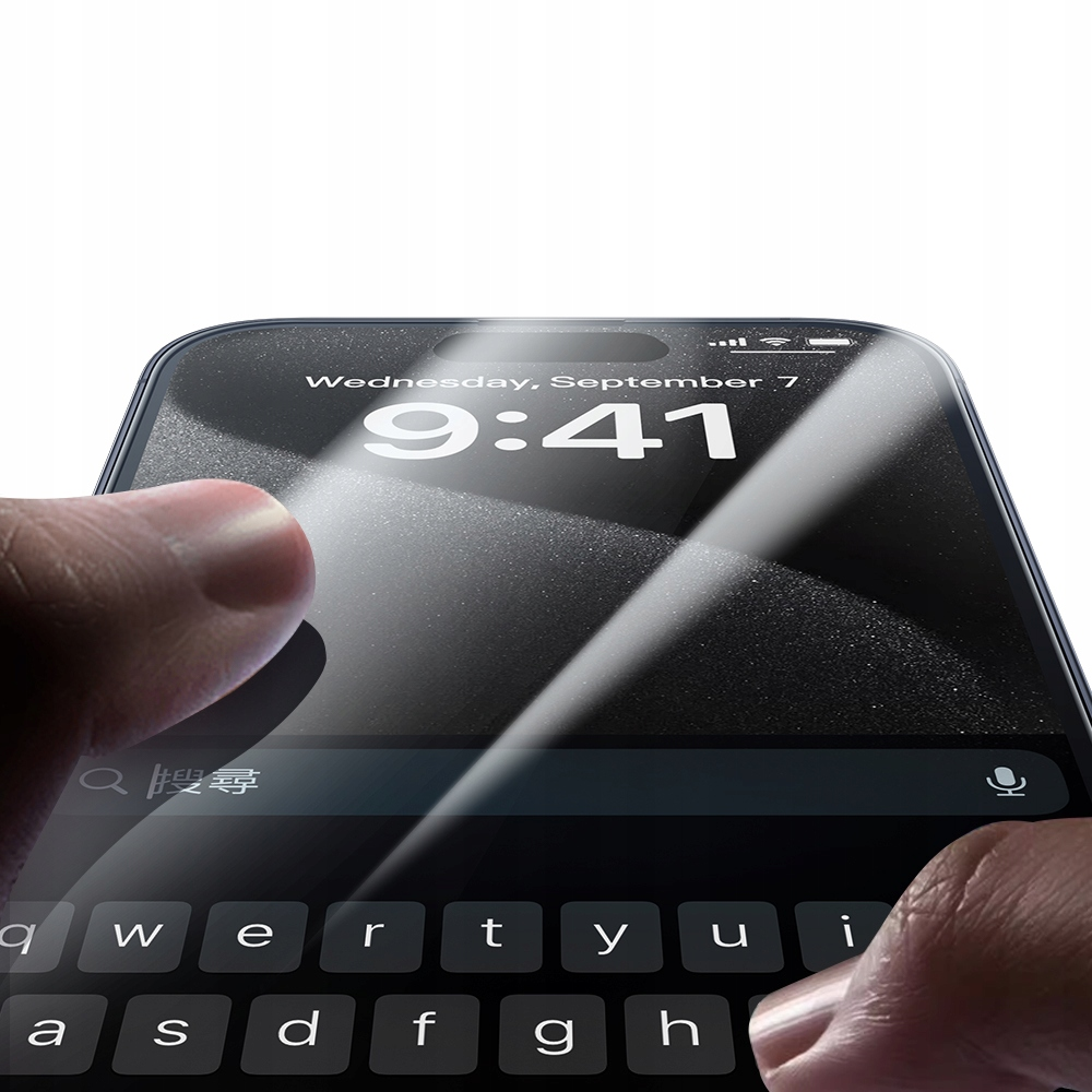 Una persona che applica una protezione per lo schermo trasparente su uno smartphone con tastiera.