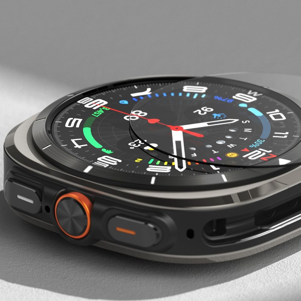 Primo piano di un moderno smartwatch con quadrante nero, pulsante arancione e lancette bianche su sfondo grigio.