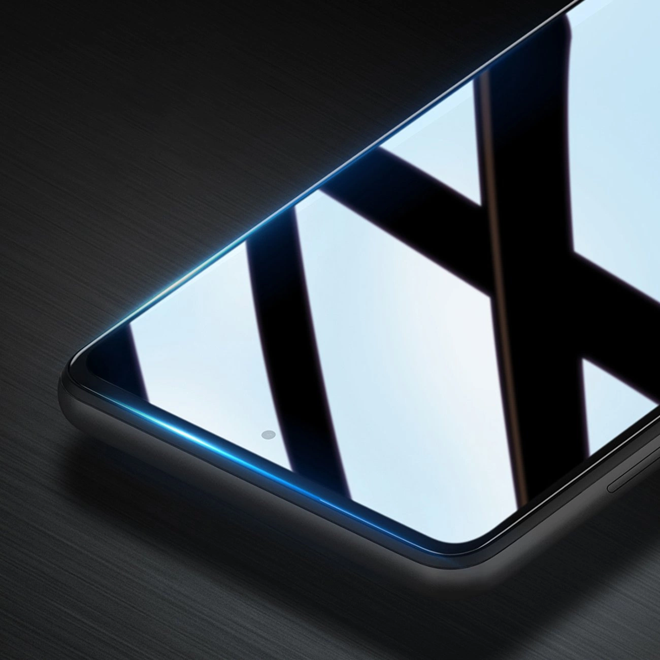 Uno smartphone con schermo in vetro che riflette la luce si trova su una superficie scura.