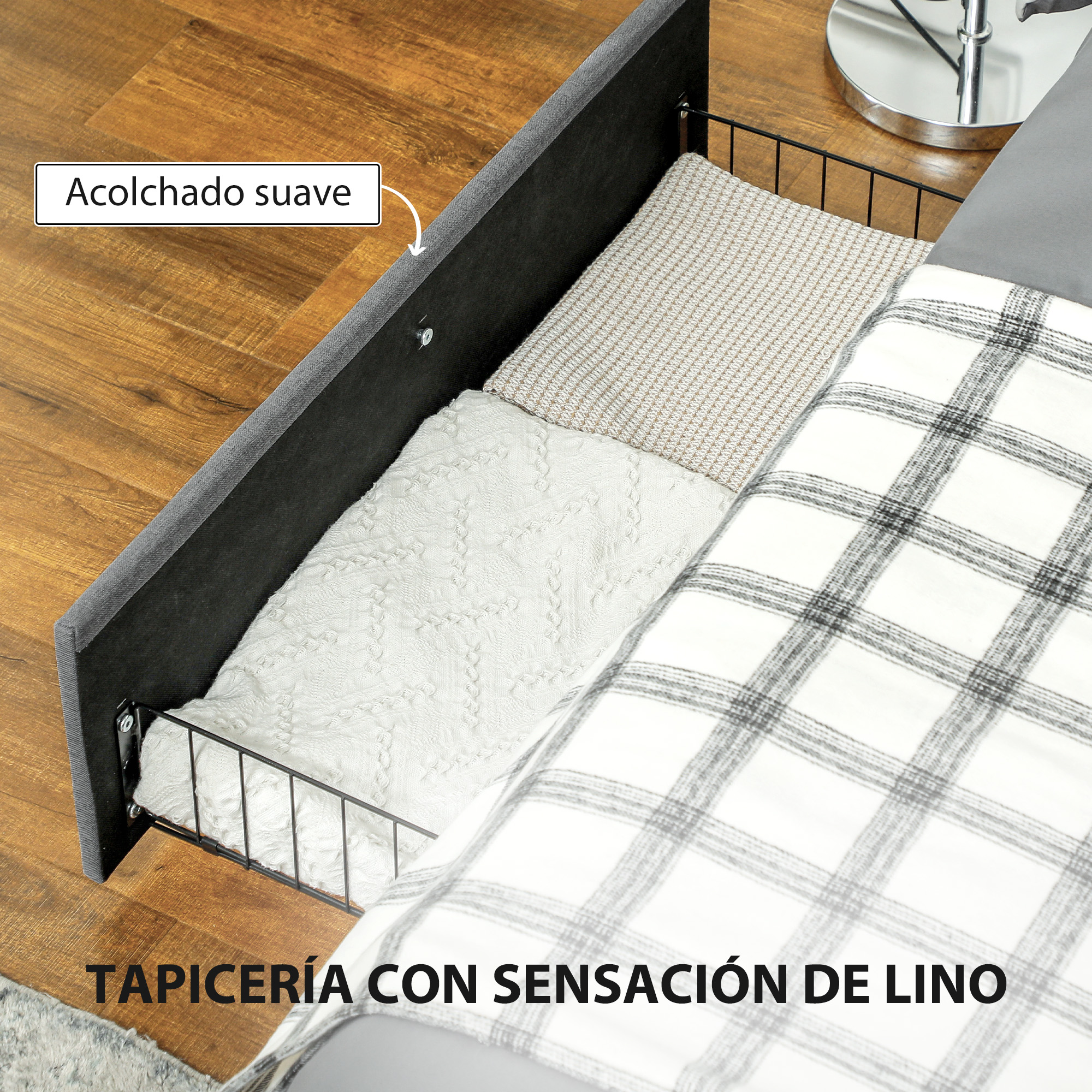 Cajón de almacenamiento tapizado bajo la cama con mantas dobladas junto a una cama.